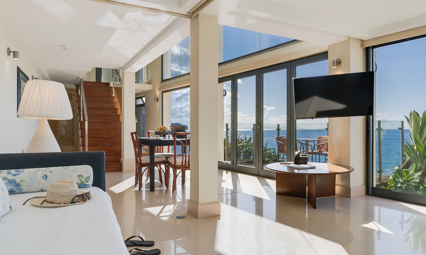 The Duplex Sea View Suite at Pestana Vila Lido Madeira features a spacious living room with sea view, sofa, and dining table
