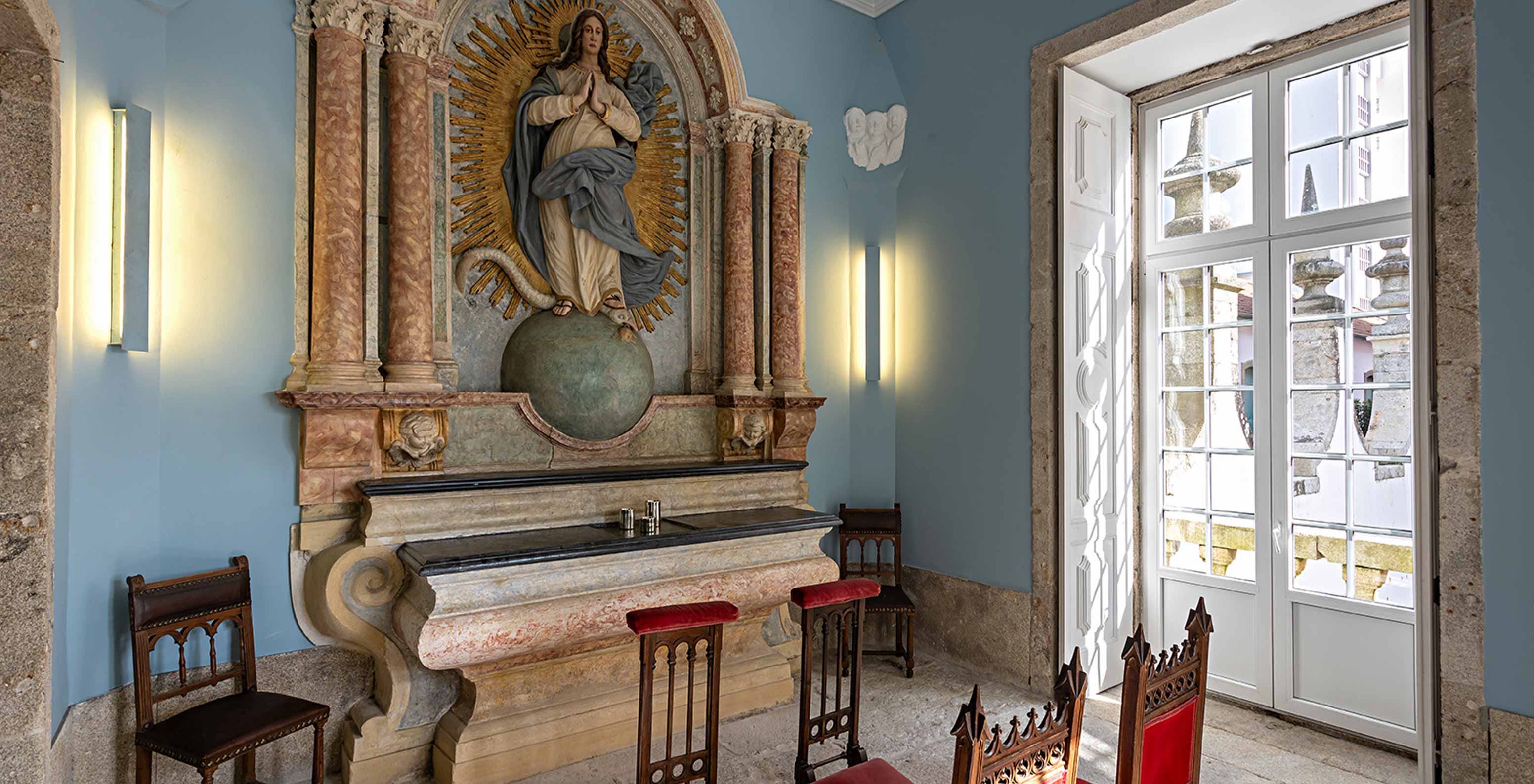 Chapel at Pestana Palácio do Freixo, a Historic Hotel by the Douro River, with an altar and benches