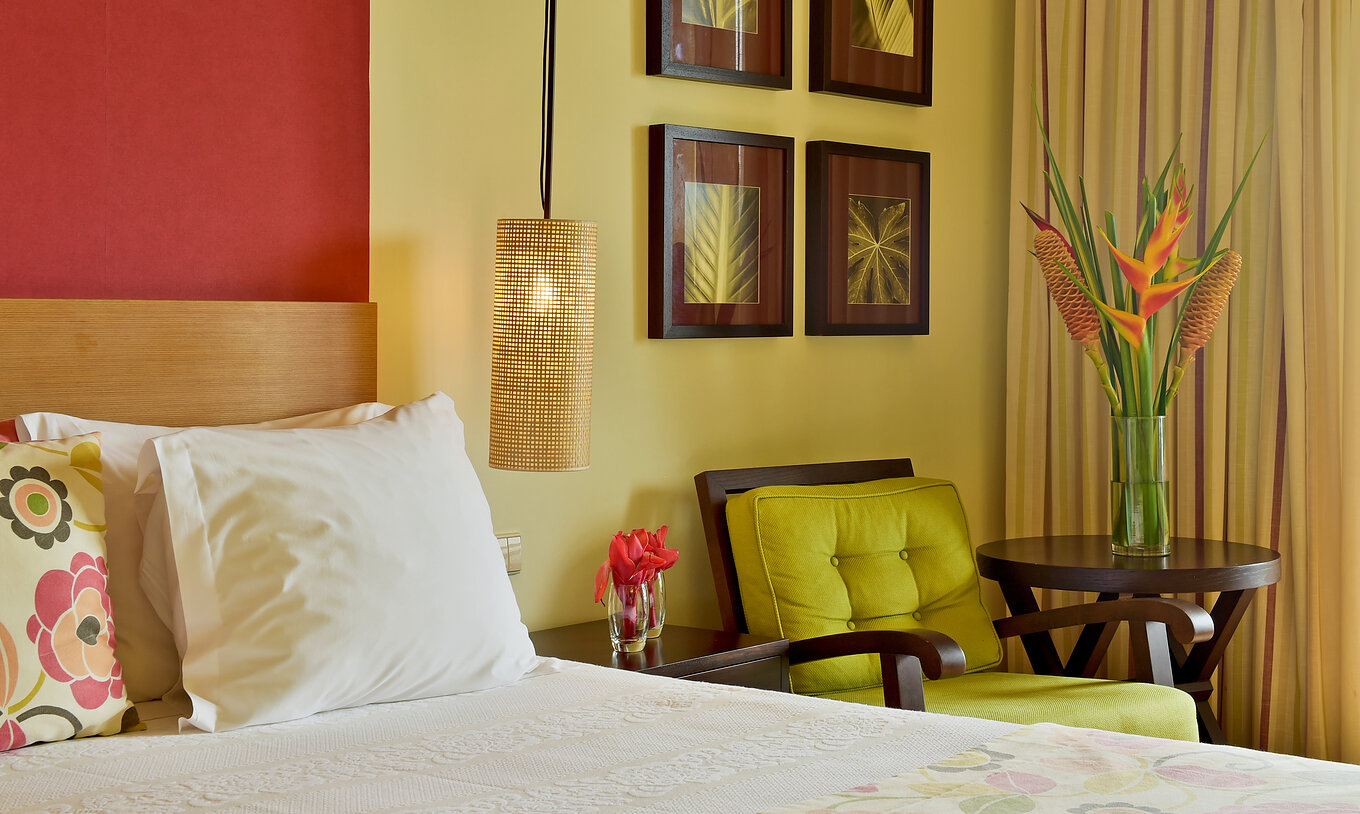 The Standard Room of Pestana São Tomé has two single beds and a warm decor with floral accents