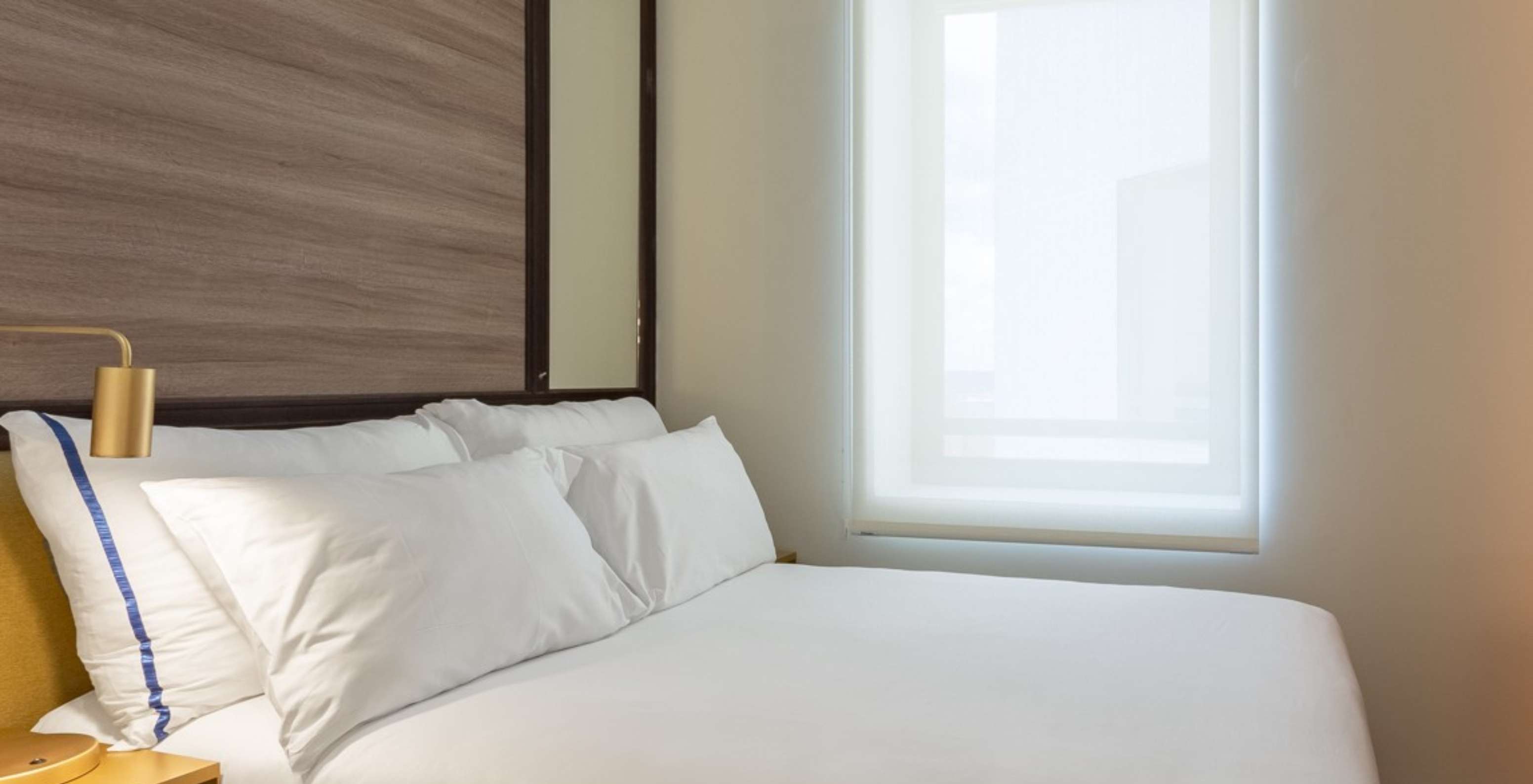 The Small Double Room at Pestana CR7 Gran Vía Madrid has a double bed, a window, and a yellow bedside table