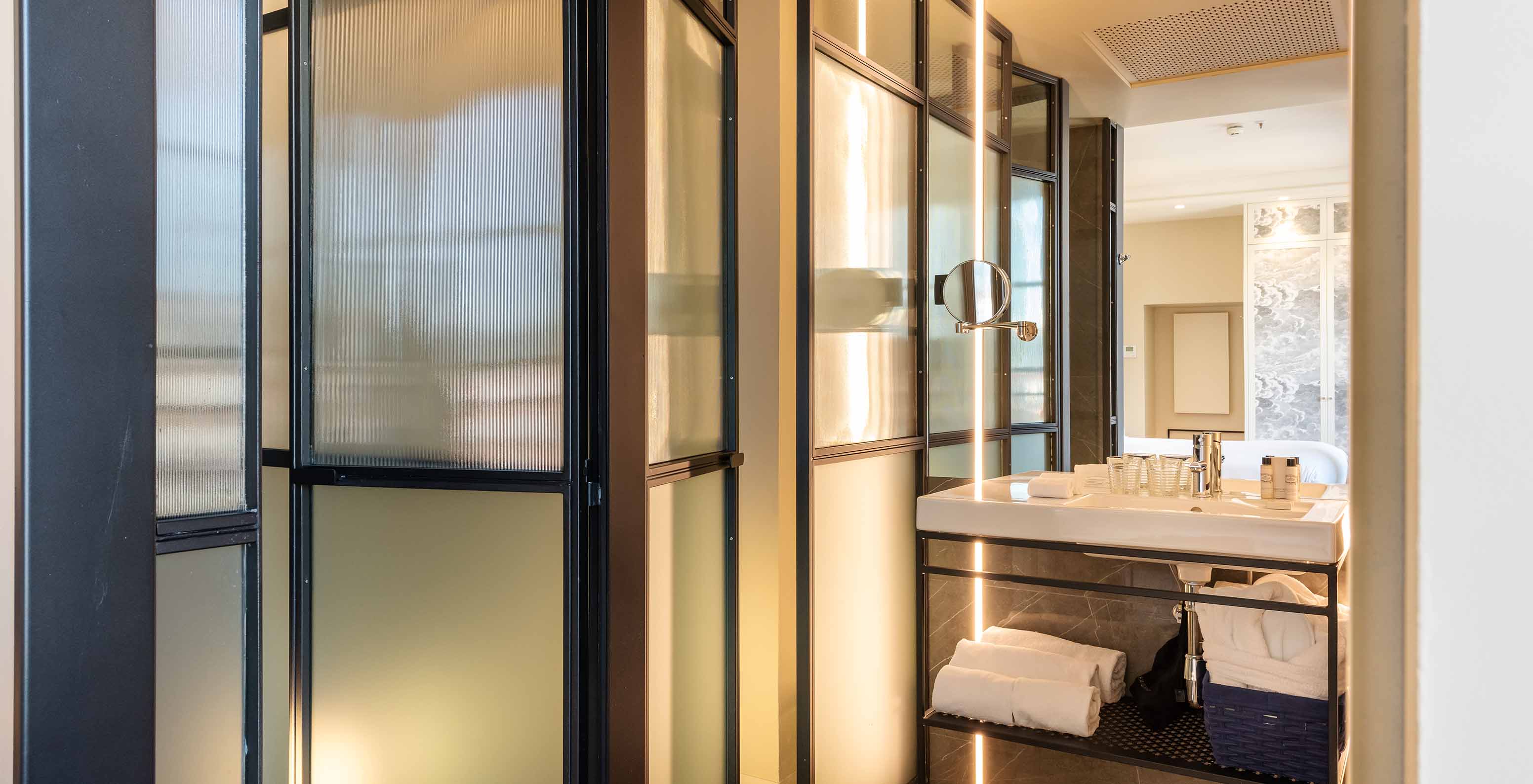 The Deluxe Grand Plaza Mayor at Pestana Collection Plaza Mayor has a bathroom with sink with mirror and towels