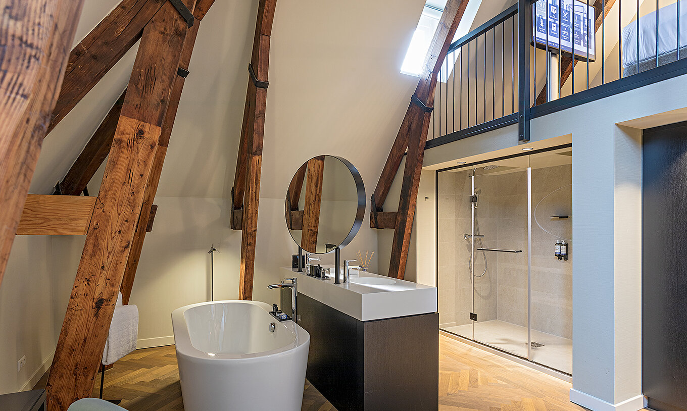 Clock Tower Suite at Pestana Amsterdam Riverside has a bathroom with two sinks, mirror and bathtub or shower