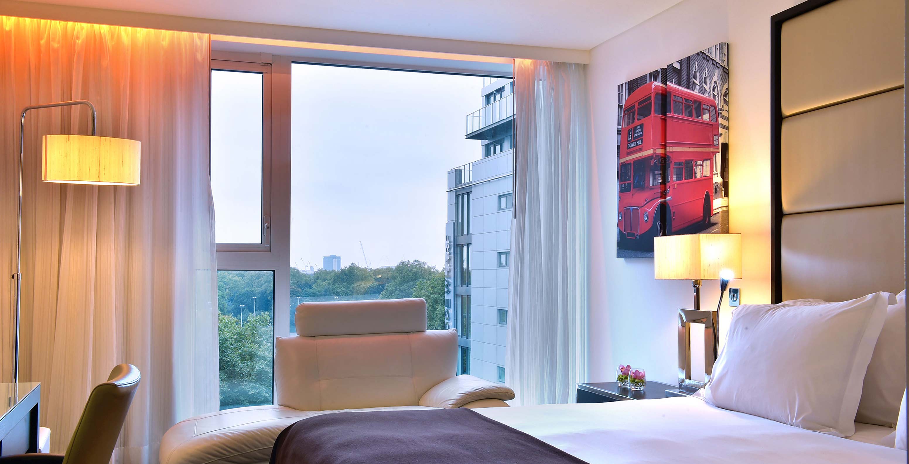 The Premium King at Pestana Chelsea Bridge has double bed, desk with chair, sofa and large window with view