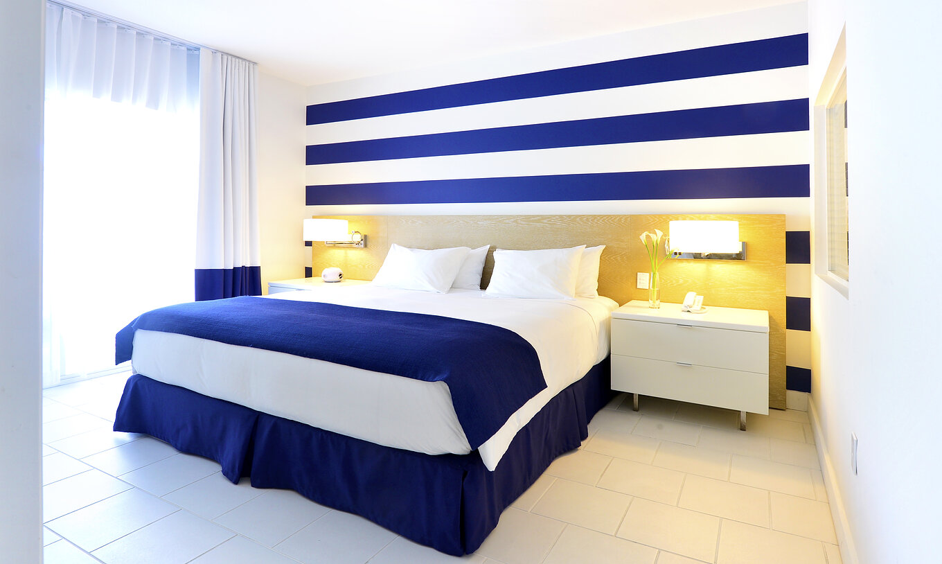 The Suite King with Balcony at Pestana Miami South Beach has a double bed, bedside table and lamp
