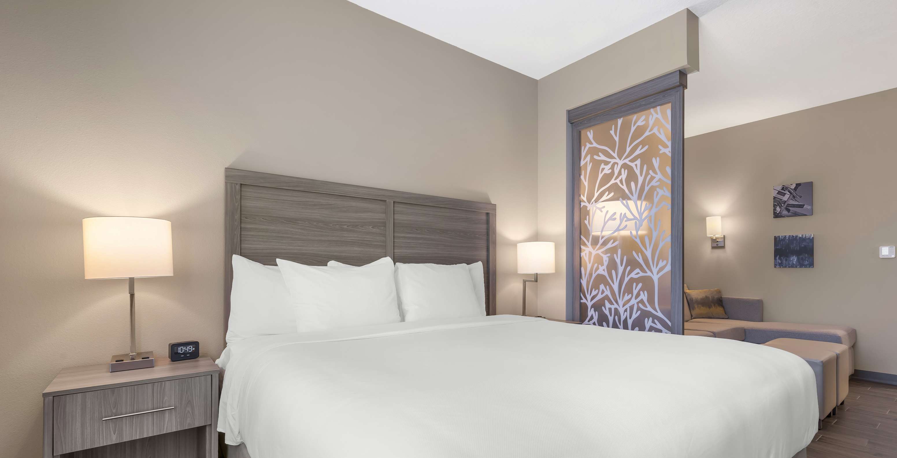 The King Master Suite at Pestana Orlando Suites Lake Buena Vista has a double bed and a bedside table with a lamp