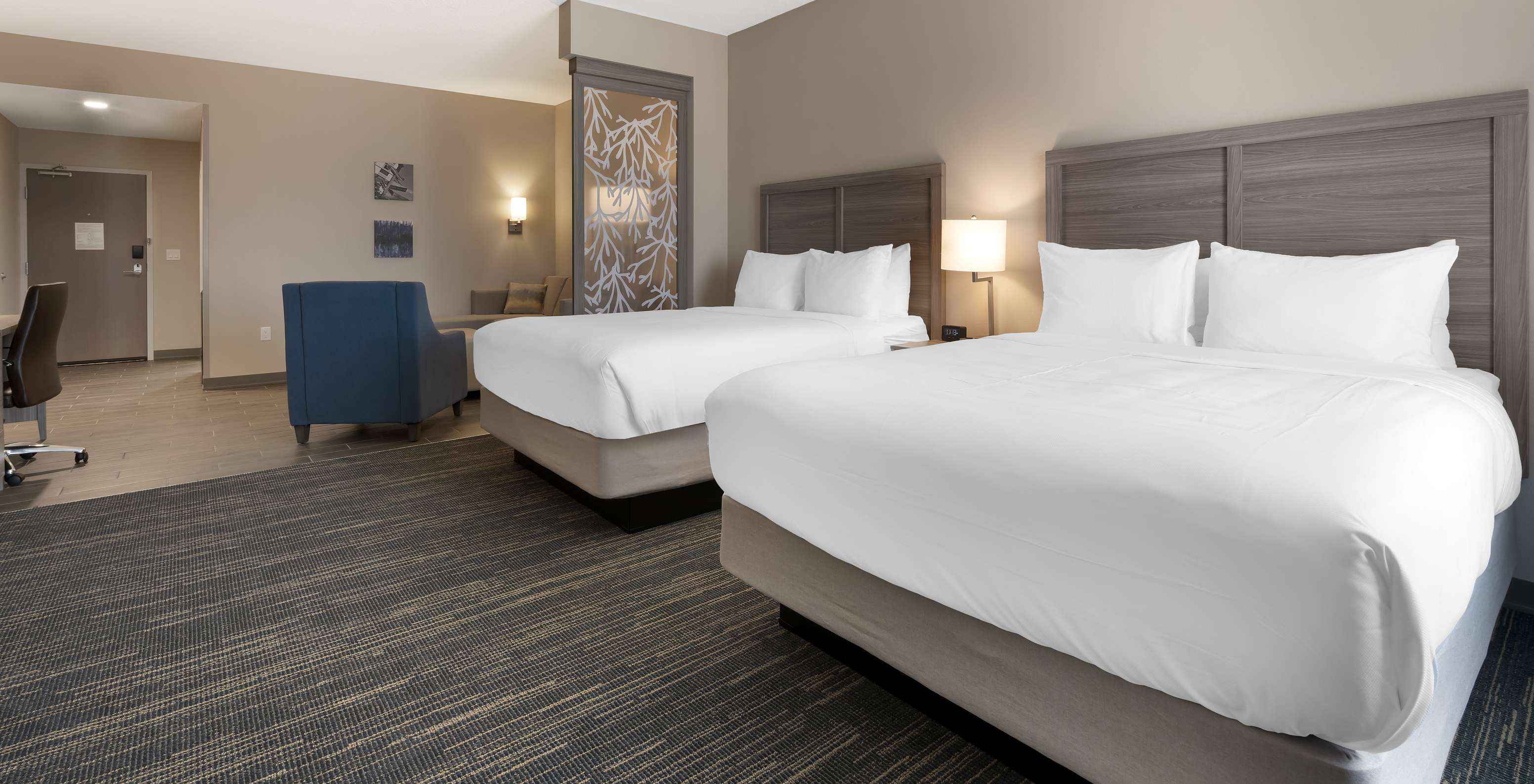 The Master Double Queen Suite at Pestana Orlando Suites Lake Buena Vista includes two double beds and an armchair