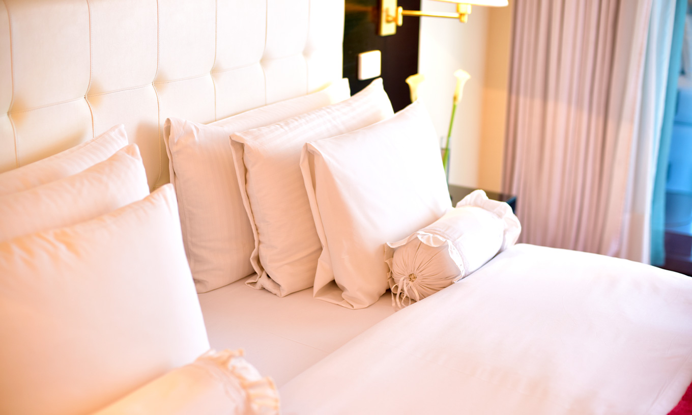 La habitación Queen Superior del Pestana Buenos Aires cuenta con una cama de matrimonio con varios tipos de almohadas