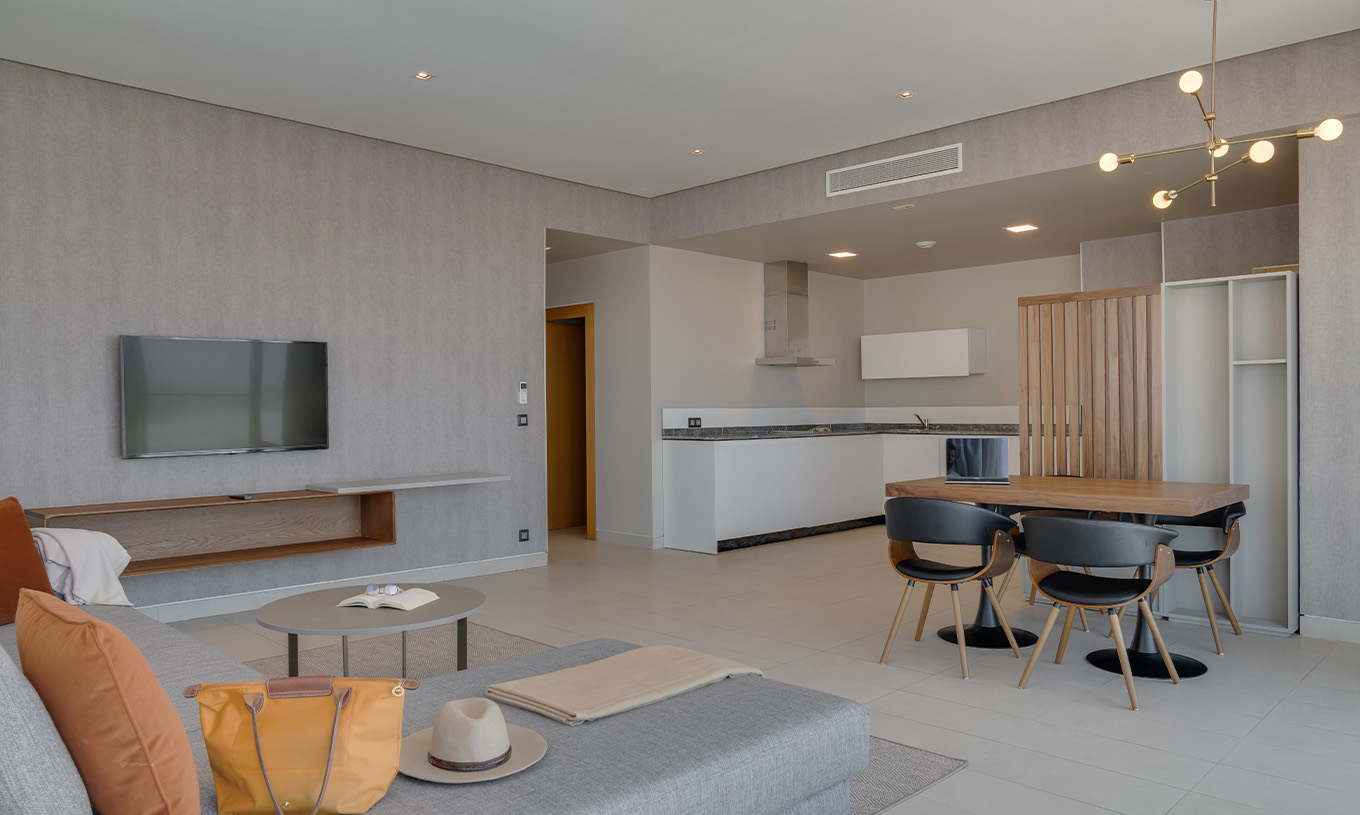 La Suite Familiar Corniche del Pestana Casablanca tiene sala espaciosa con sofá, tv, mesa de comida y kitchenette
