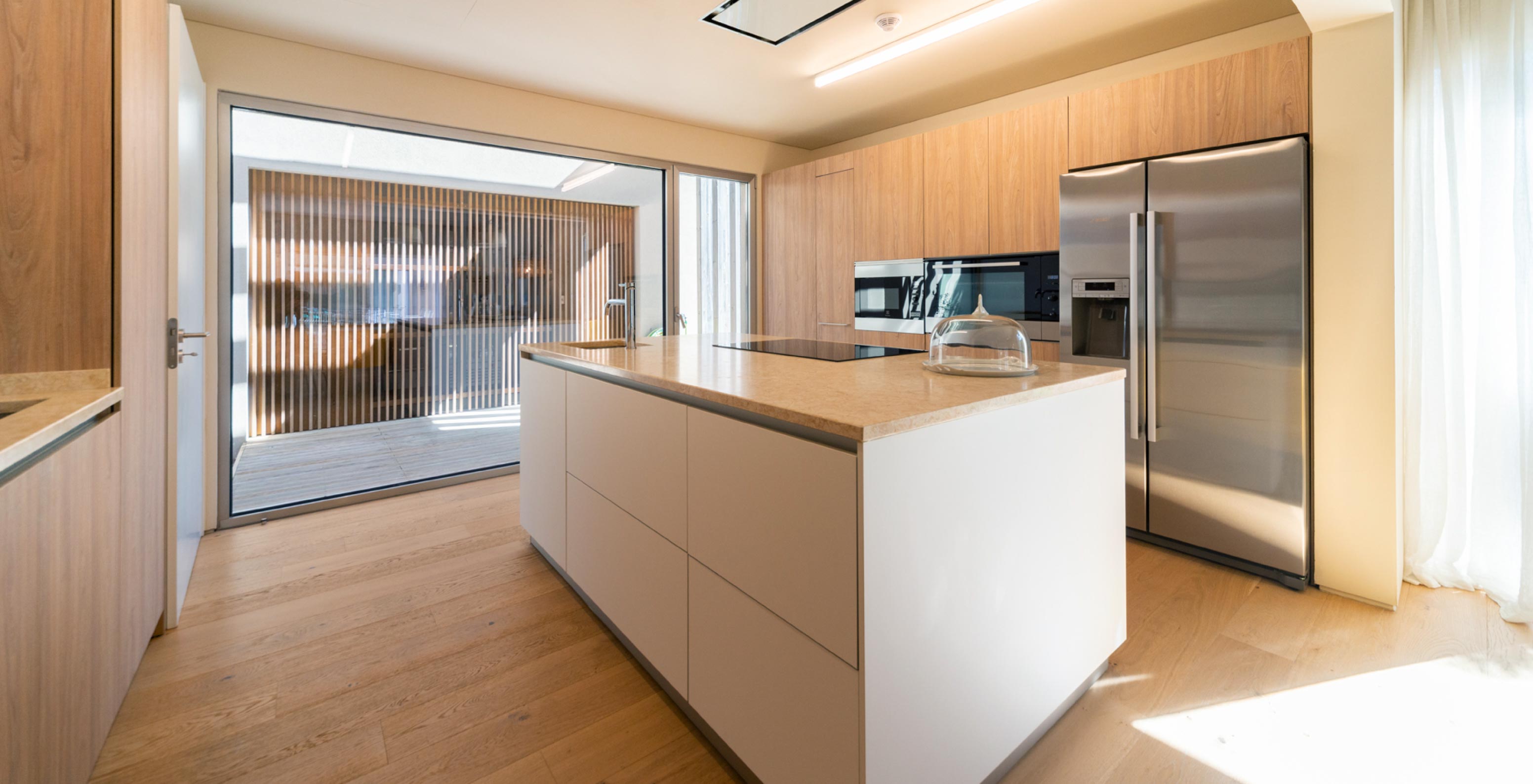 La villa exclusiva con piscina del Pestana Tróia Eco Resort tiene una cocina equipada, armarios de madera y una isla central