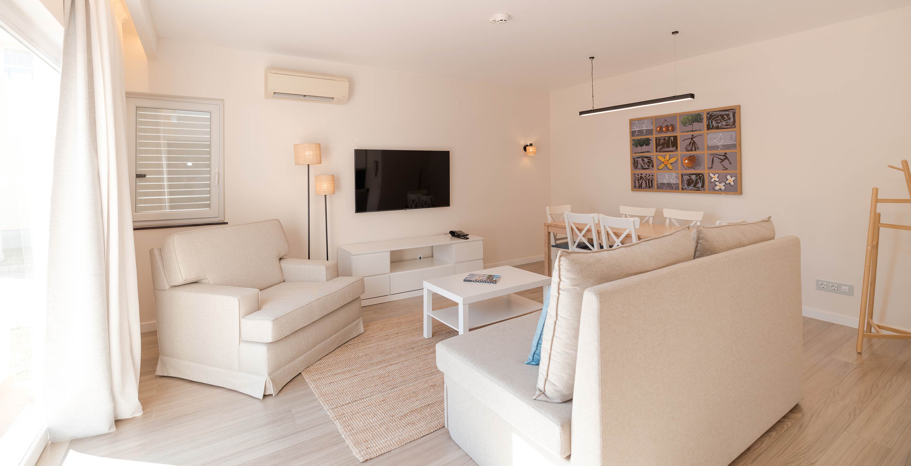 Villa 2 Habitaciones Premium en Pestana Alvor Beach Villas tiene sala con sofás beige, TV y aire acondicionado