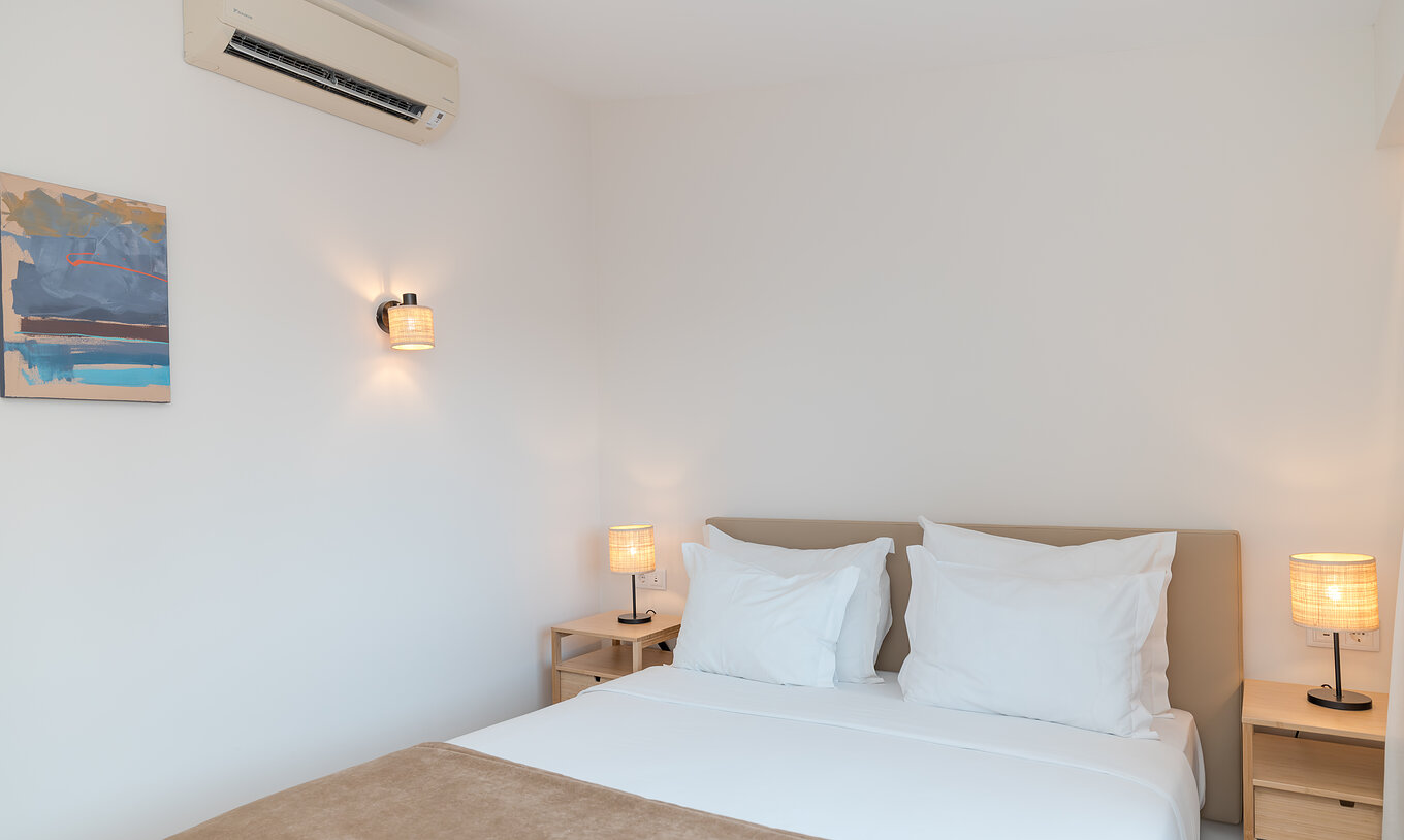 Villa 2 Habitaciones Vista Jardín en Pestana Alvor Beach Villas tiene habitación con cama doble, cuadro y aire acondicionado