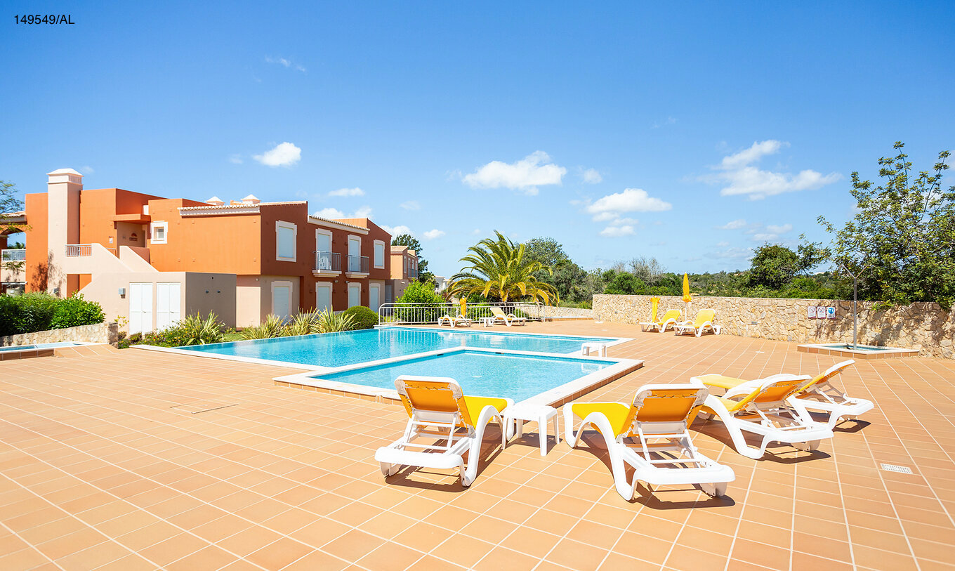 El apartamento Pestana Carvoeiro Golf T2 Superior tiene un patio exterior con piscina y tumbonas amarillas
