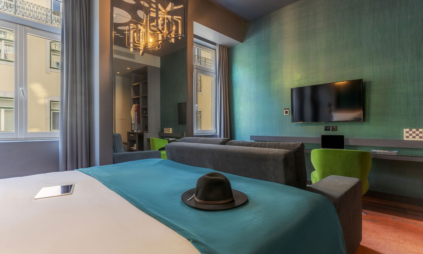 El CR7 Familiar Hat-Trick del Pestana CR7 Lisboa tiene un espejo, un sofá con televisión y una cama