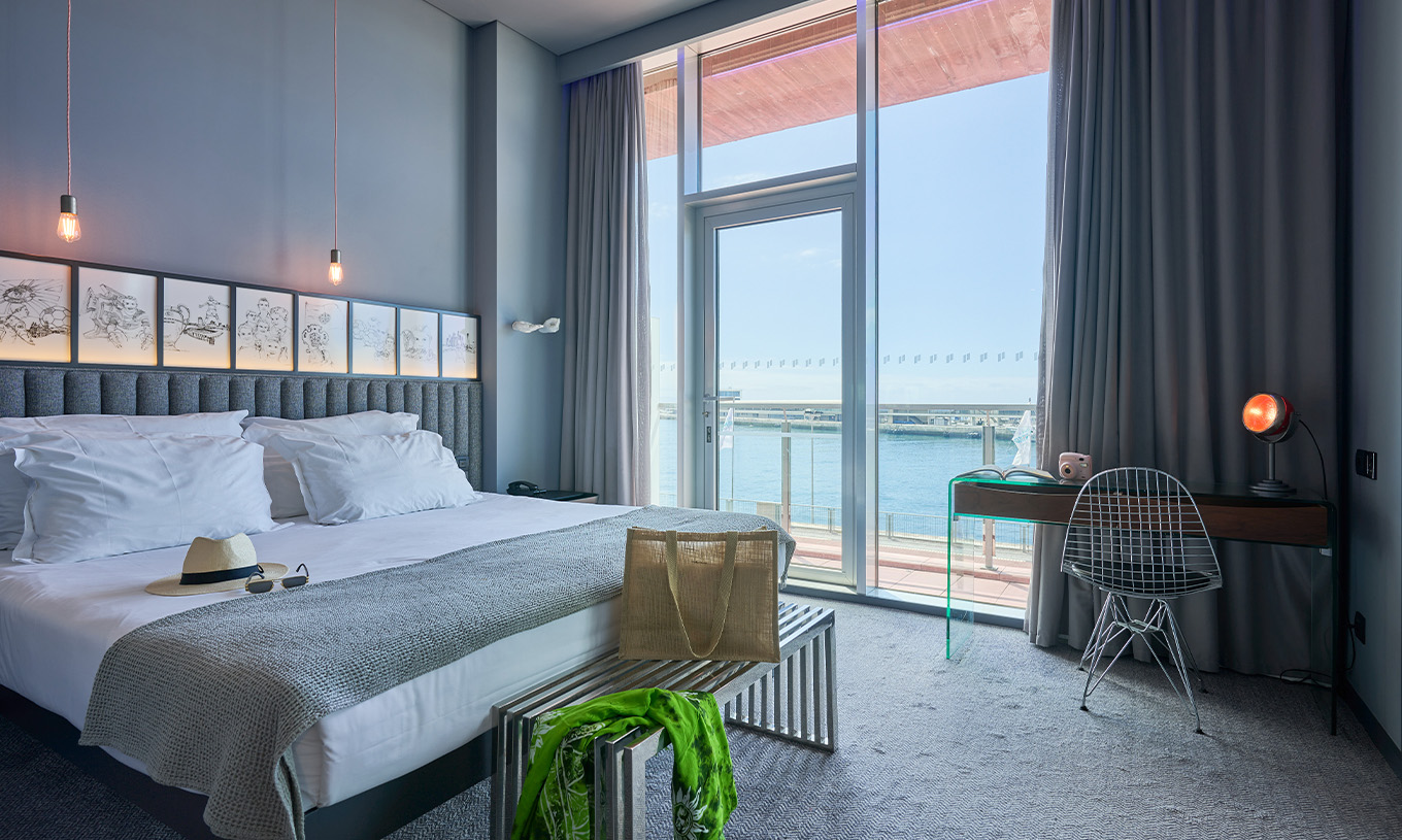 La Habitación CR Superior del Pestana CR7 Funchal tiene una cama doble al lado del balcón, donde se puede ver el mar