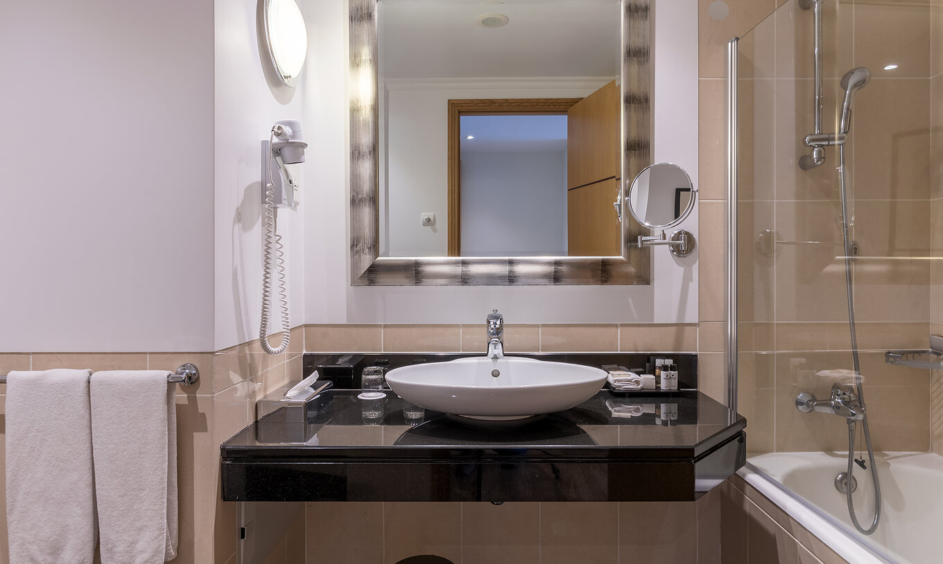 La Standard Suite Vista Mar del Pestana Grand tiene un baño con lavamanos, bañera con ducha y toalla