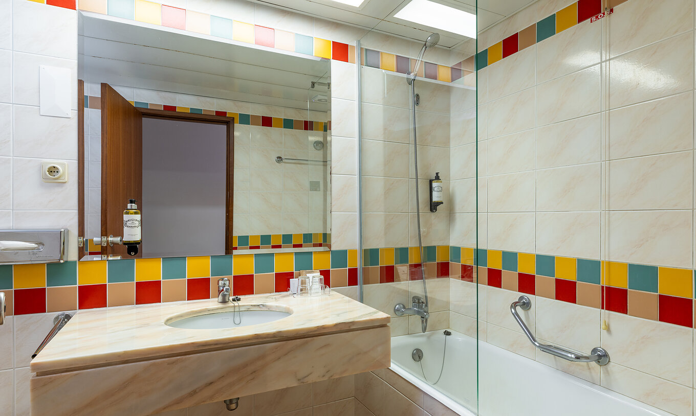 El Classic Sea View del Pestana Ocean Bay All Inclusive tiene un baño con bañera y lavabo con espejo