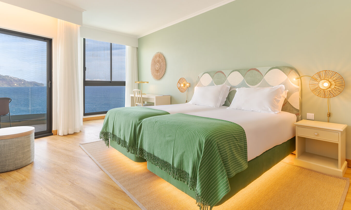 El Superior Vista Mar del Pestana Vila Lido Madeira tiene tonos verdes, dos camas, un escritorio con silla y un balcón