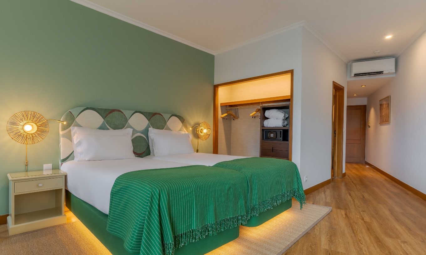 La habitación Superior Vista Mar Lateral del Pestana Vila Lido Madeira tiene cama doble con cabecero verde y armario.