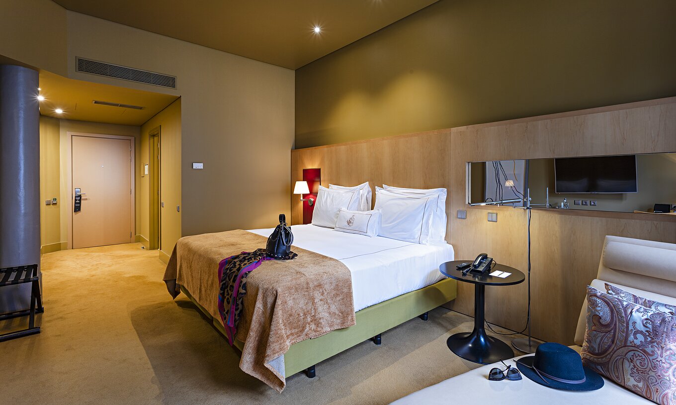 La habitación Clásica del Pestana Palácio do Freixo tiene paredes amarillas, cama doble y sofá cama beige