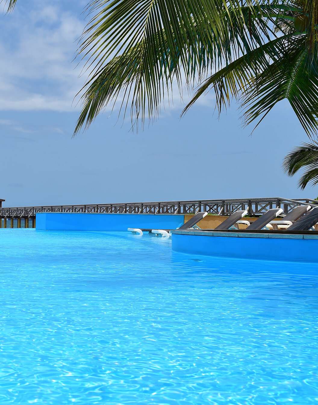 Vista paradisíaca de la piscina Pestana São Tomé que se funde con el mar cristalino un escenario tropical
