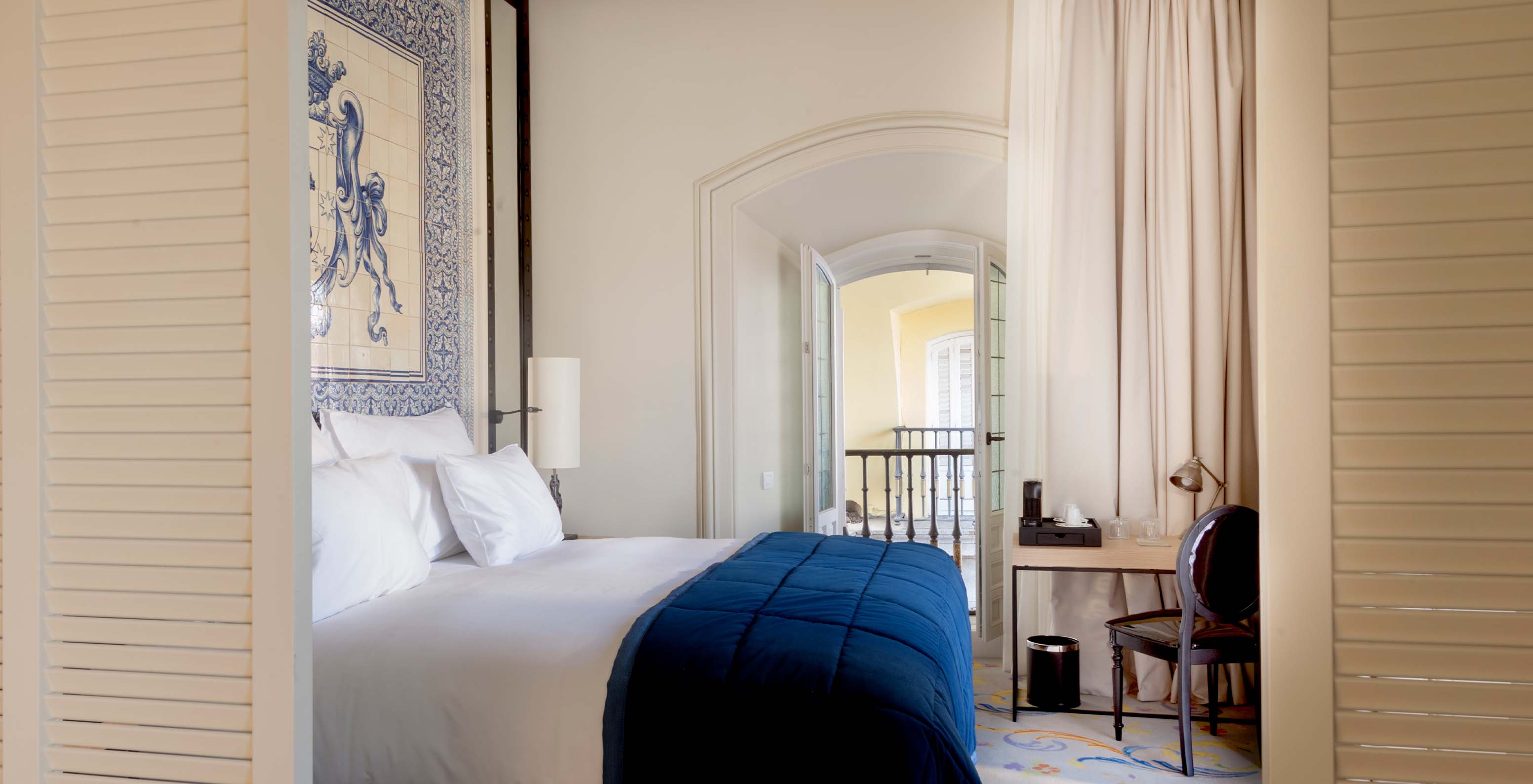 La Suite Plaza Mayor del Pestana Collection Plaza Mayor tiene una cama de casal y una cabecera con azulejos azules y blancos