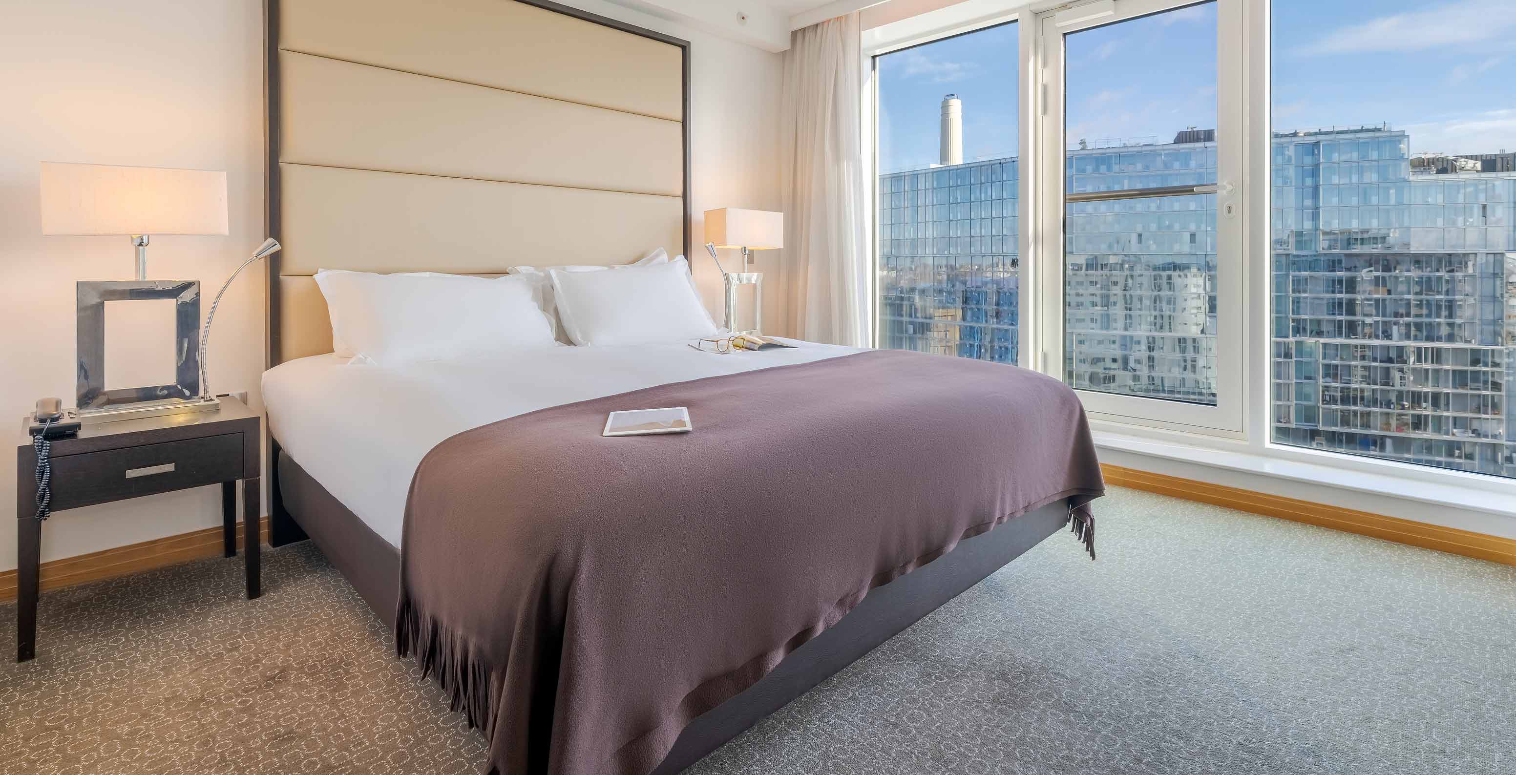 El Superior King del Pestana Chelsea Bridge tiene cama doble con sábanas blancas y ventana grande con vista a la ciudad