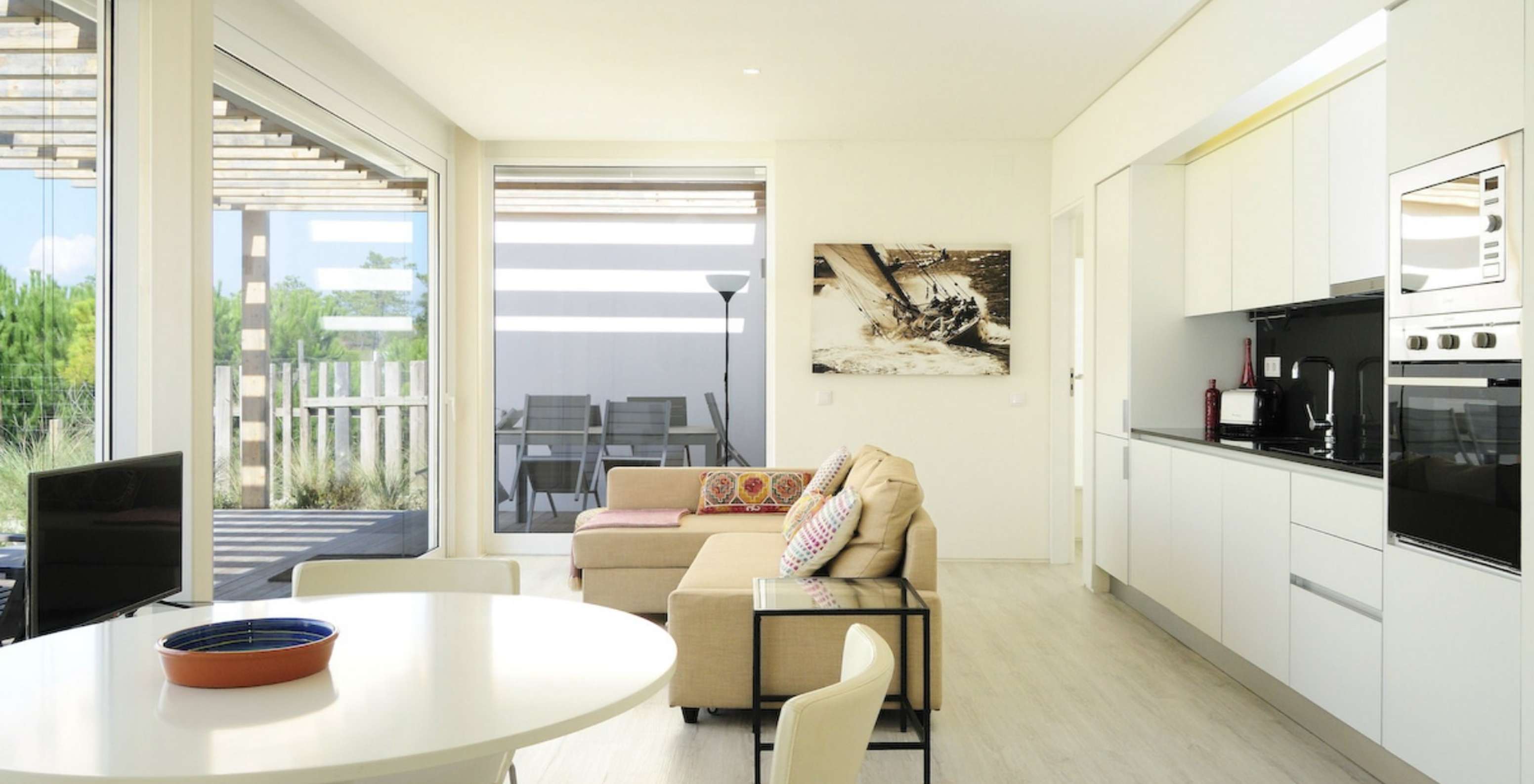 La Green Villa T3 del Pestana Tróia Eco Resort tiene una sala junta con la cocina, sofá y mesa para cenar