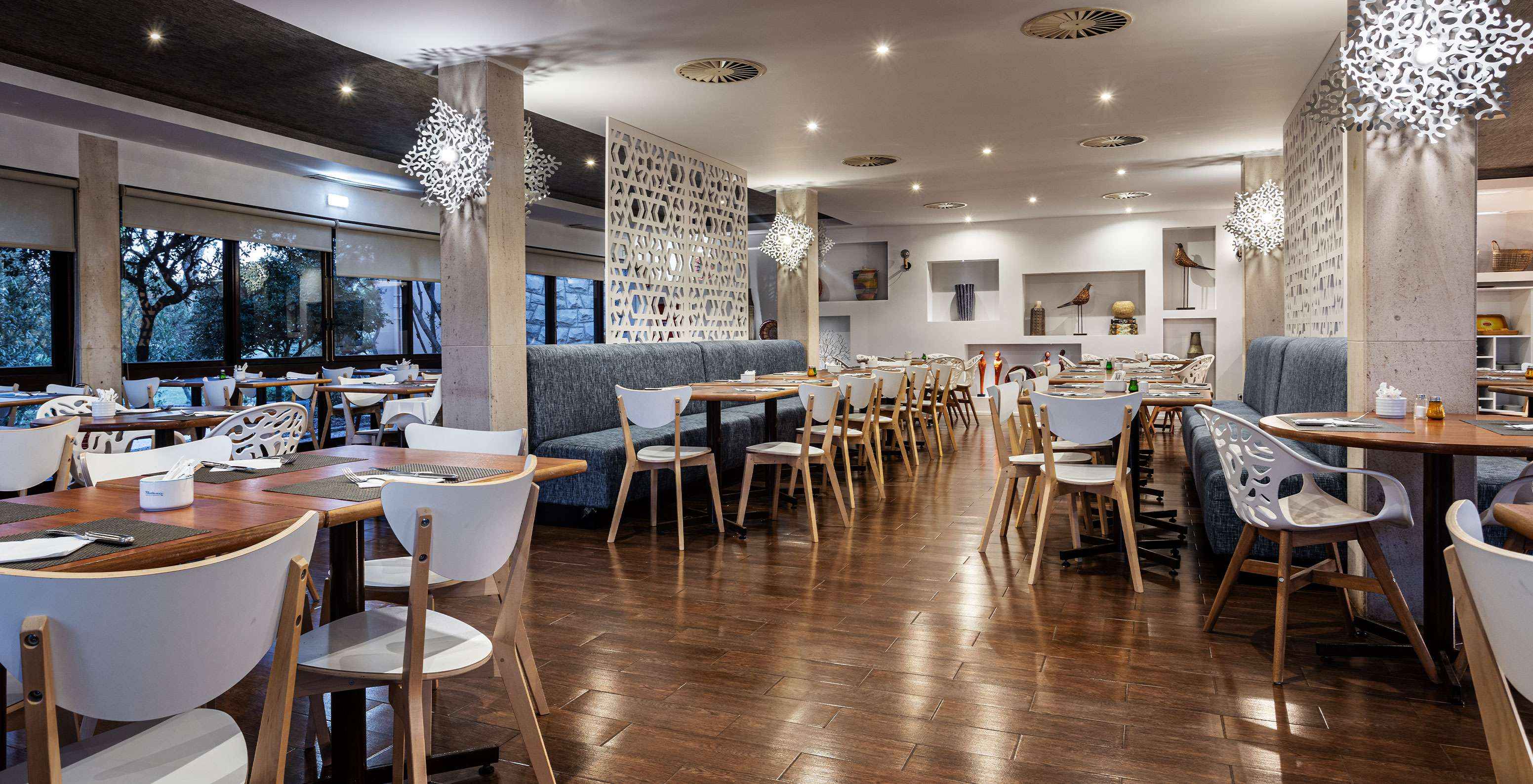 Restaurante amplio con varias mesas, sillas y sofás para disfrutar de una comida