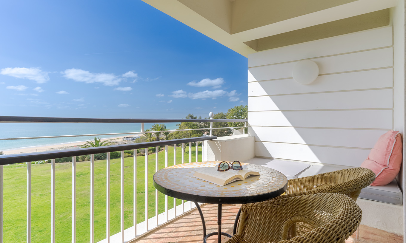 El Deluxe Vista Mar del Pestana Alvor Praia tiene terraza con sillas, mesa y sofá con vista al mar, playa y jardín