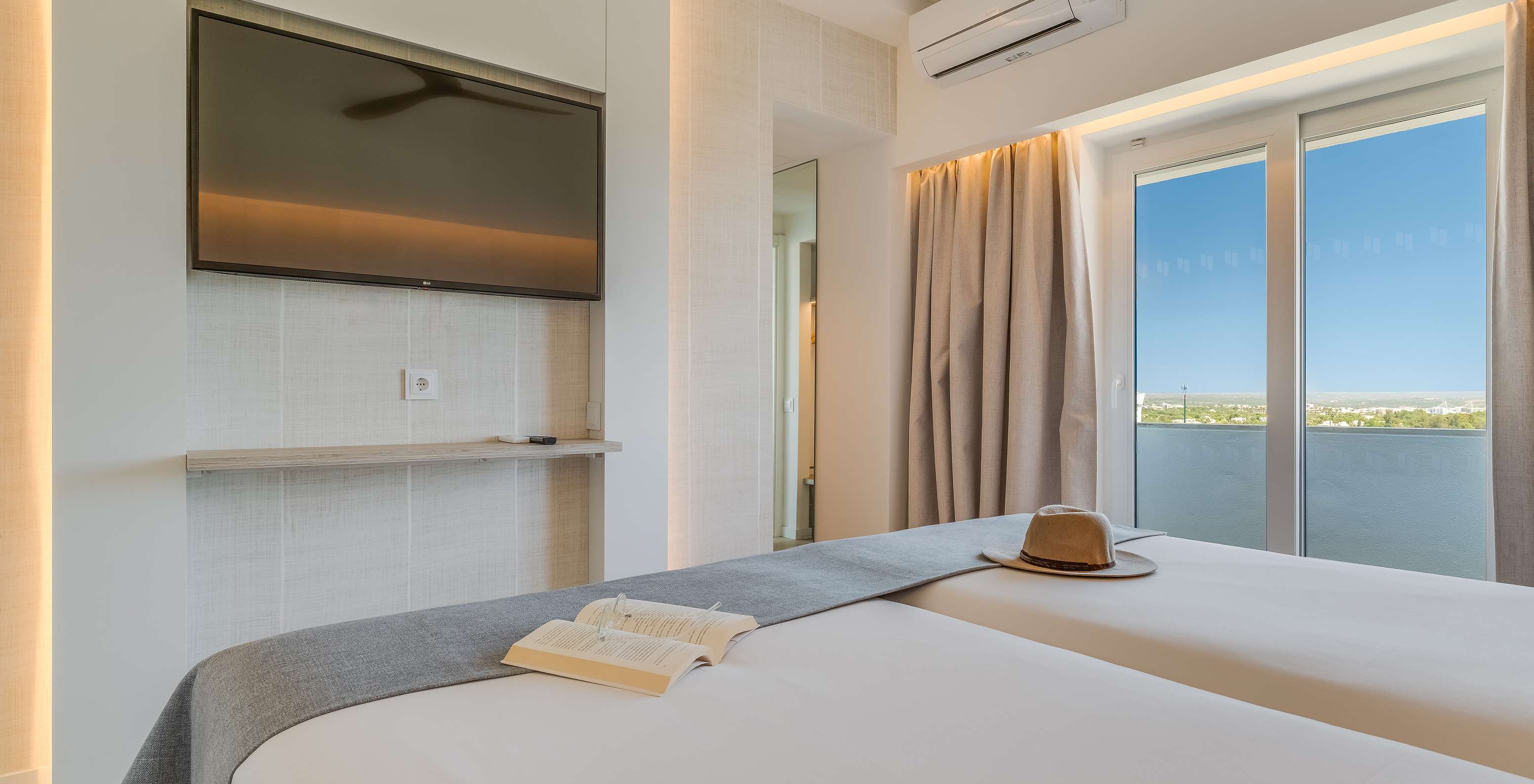 El Cuarto Clásico Vista Jardín del Pestana Blue Alvor Beach tiene dos camas, televisión, aire acondicionado y un balcón