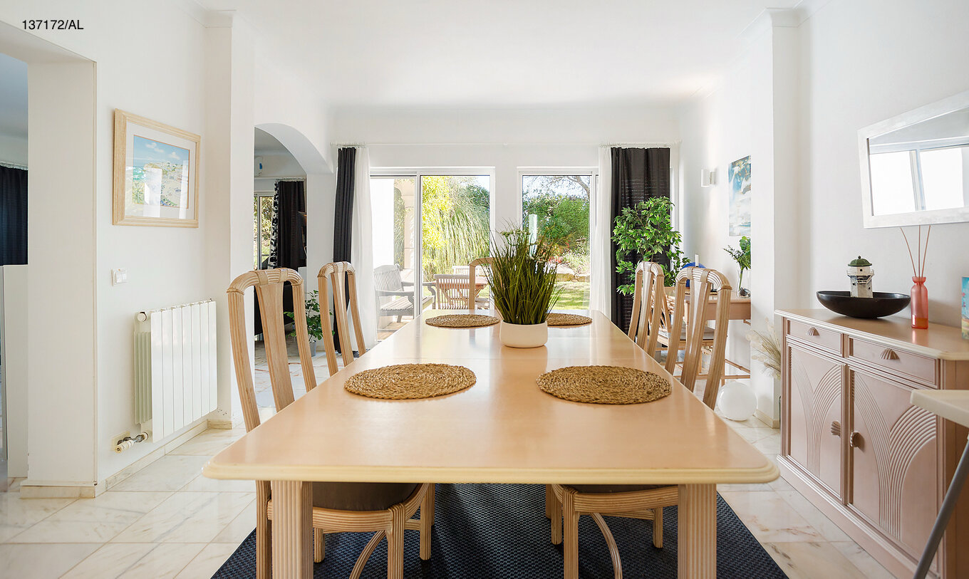 La villa Pestana Carvoeiro Golf V3 Estándar tiene un comedor con una mesa de madera larga y sillas