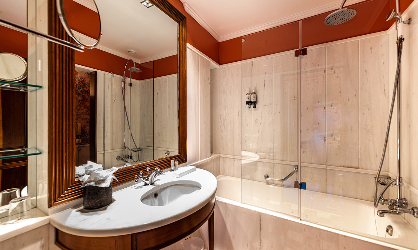 El Premium Garden del Pestana Palace Lisboa tiene un baño con bañera y lavabo de mármol y madera y espejo