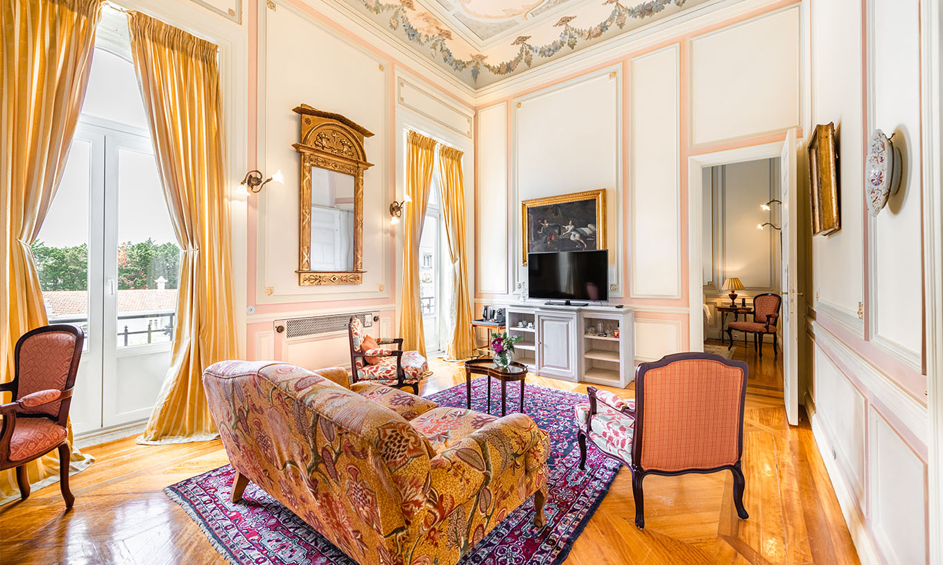 La Suite D. Amélia del Pestana Palace Lisboa tiene una sala de estar con sofá, sillas, televisión y dos grandes ventanas