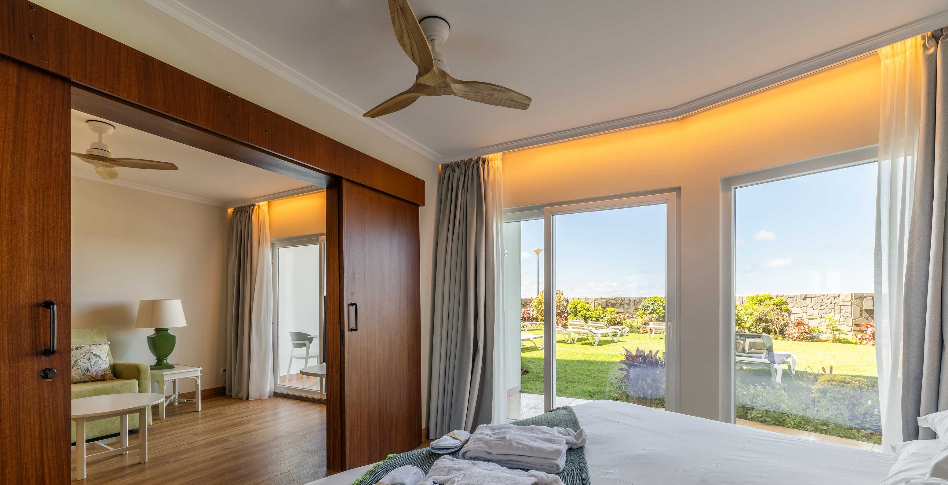 La Junior Suite Sea View del Pestana Ocean Bay All Inclusive tiene una cama de matrimonio con vistas al jardín y una sala de estar