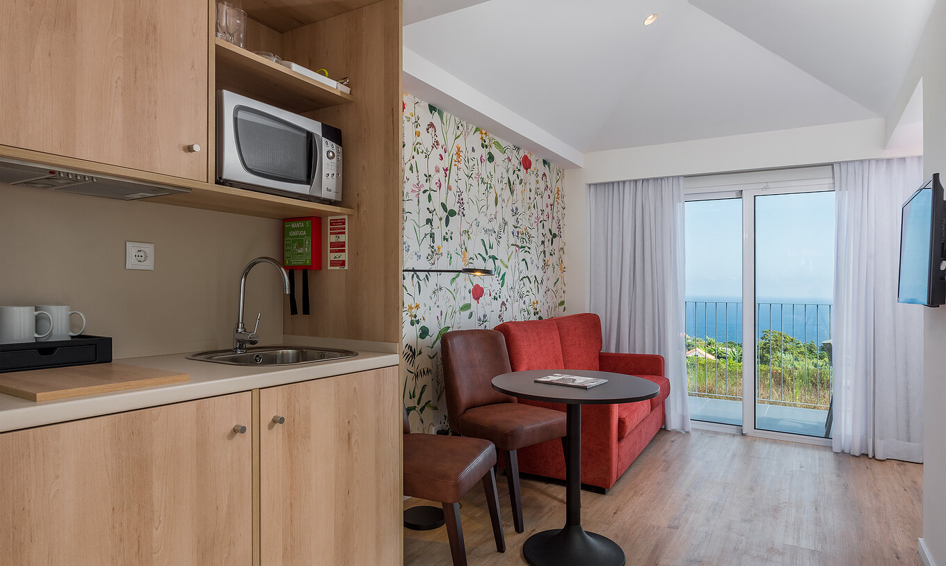 El Estudio - Vista jardín del Pestana Quinta do Arco tiene kitchenette, sofá, televisión, mesa, sillas y balcón con vista mar