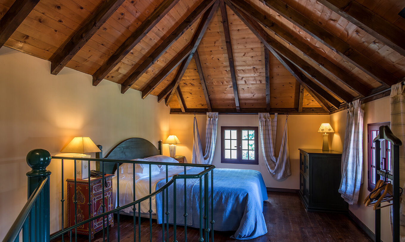 Las Villas Duplex del Pestana Quinta do Arco tienen cama de casal con techo de madera, mesas de noche y cómoda de madera