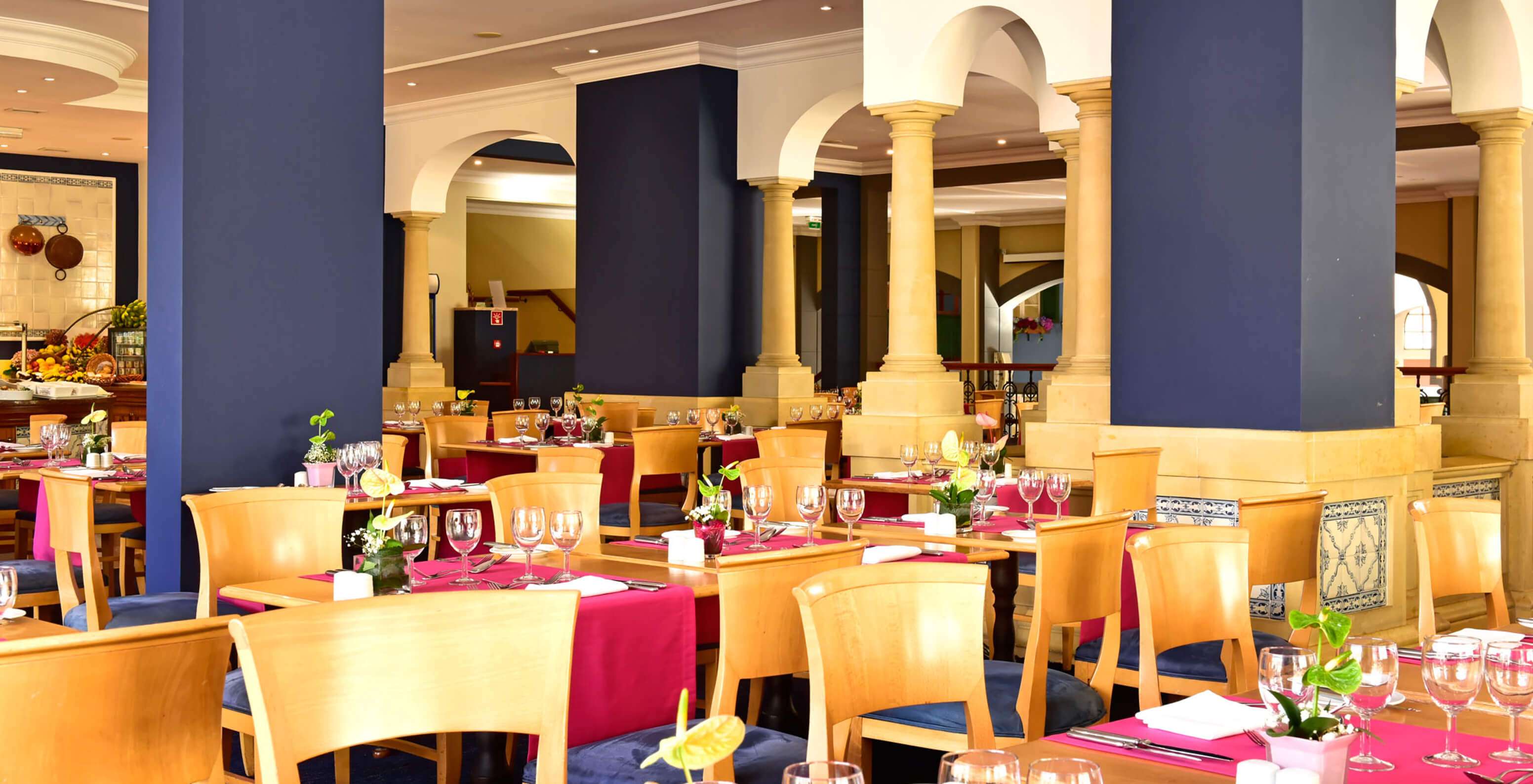 El restaurante A Vila, Hotel Romántico en Funchal, Madeira tiene varias mesas con sillas de madera