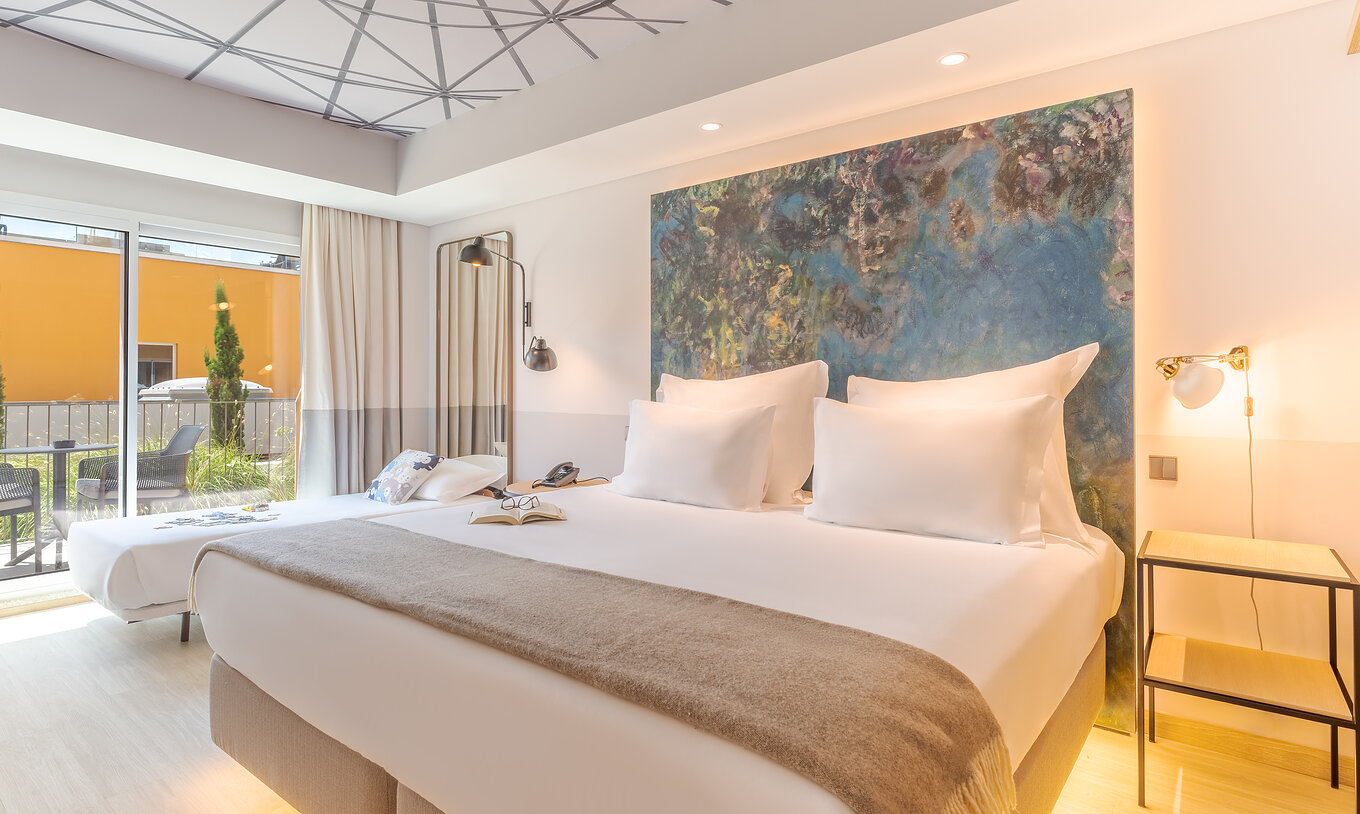 El cuarto Superior Familiar del Pestana Douro Riverside cuenta con una cama de matrimonio y una cama pequeña, mesa de noche y terraza