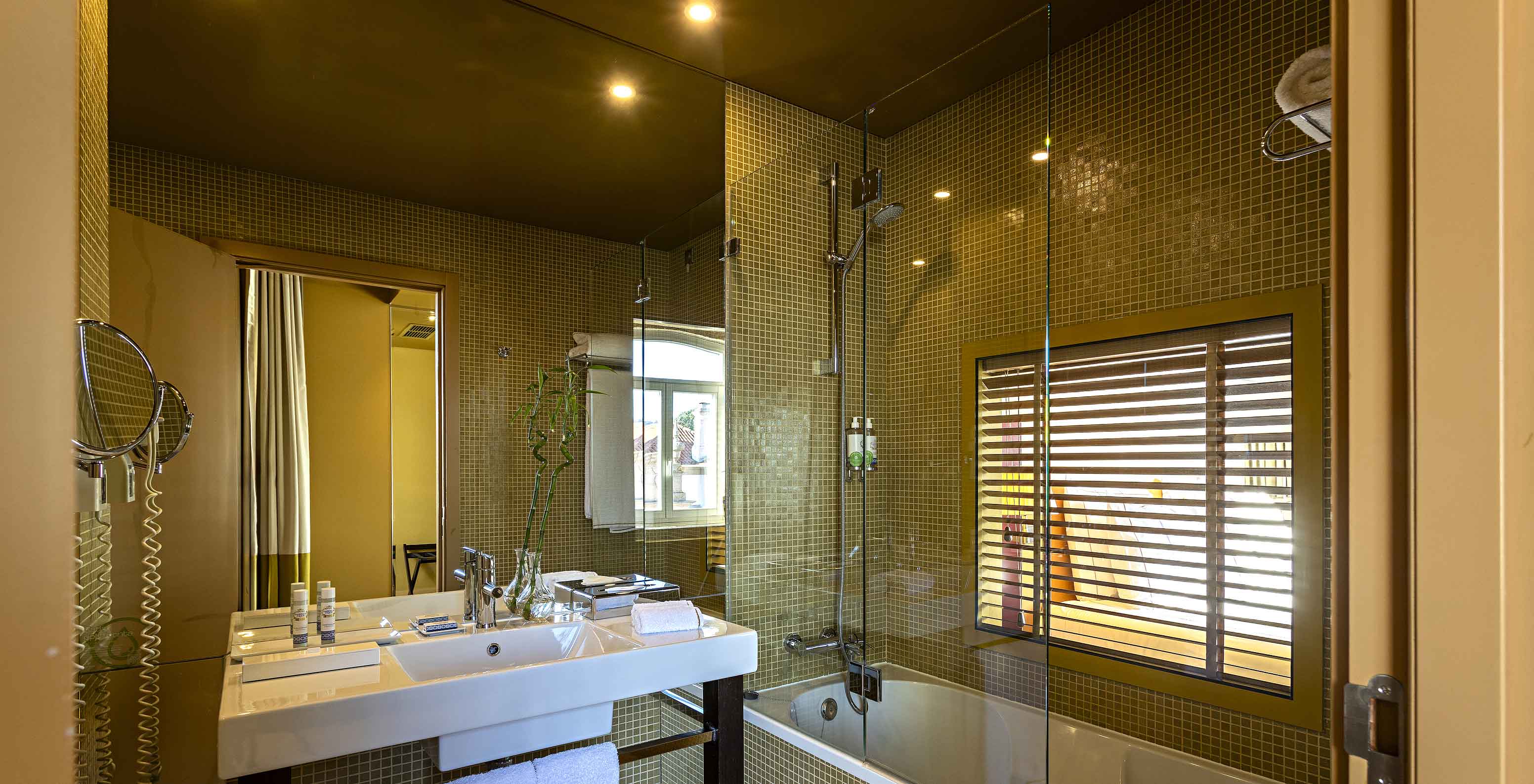 El Deluxe Grand View tiene un baño con bañera y una ventana al dormitorio