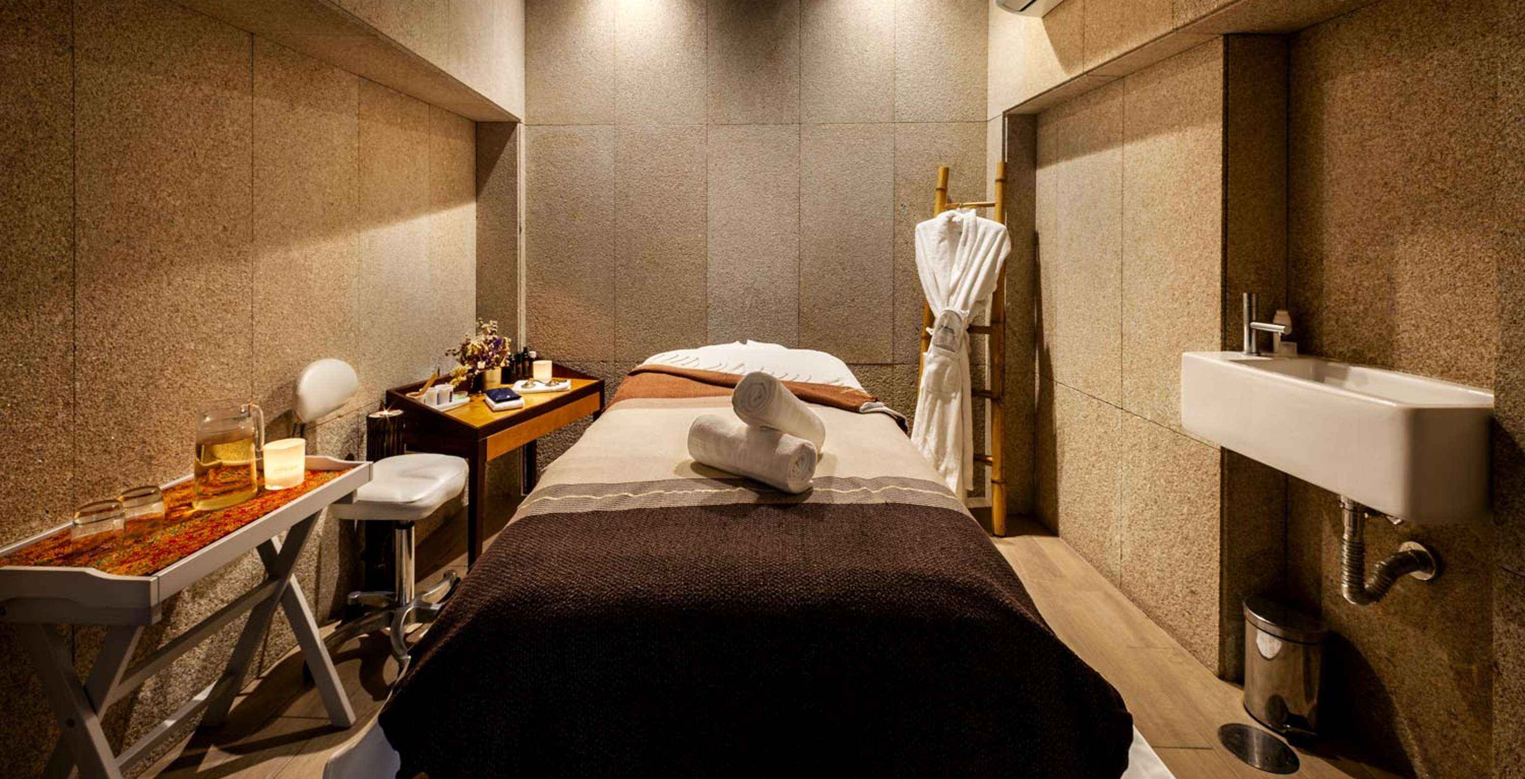 Cama del centro de bienestar con una mesa con té en Pestana Vintage Porto, un Hotel en la Praça da Ribeira