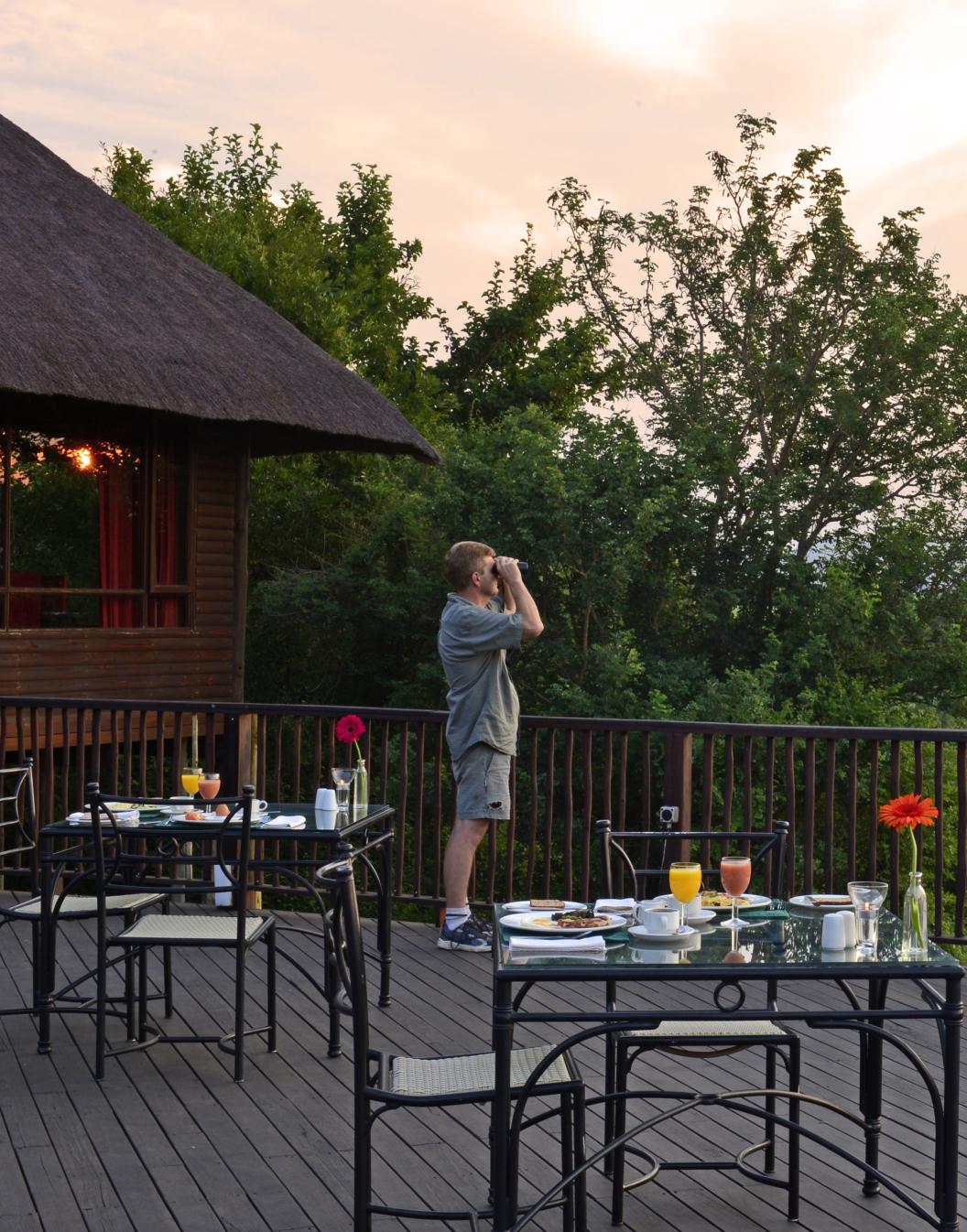 Pestana Kruger Lodge, hotel de 4 estrellas en Kruger Park, con mesas en el balcón para comidas y avistamiento de animales