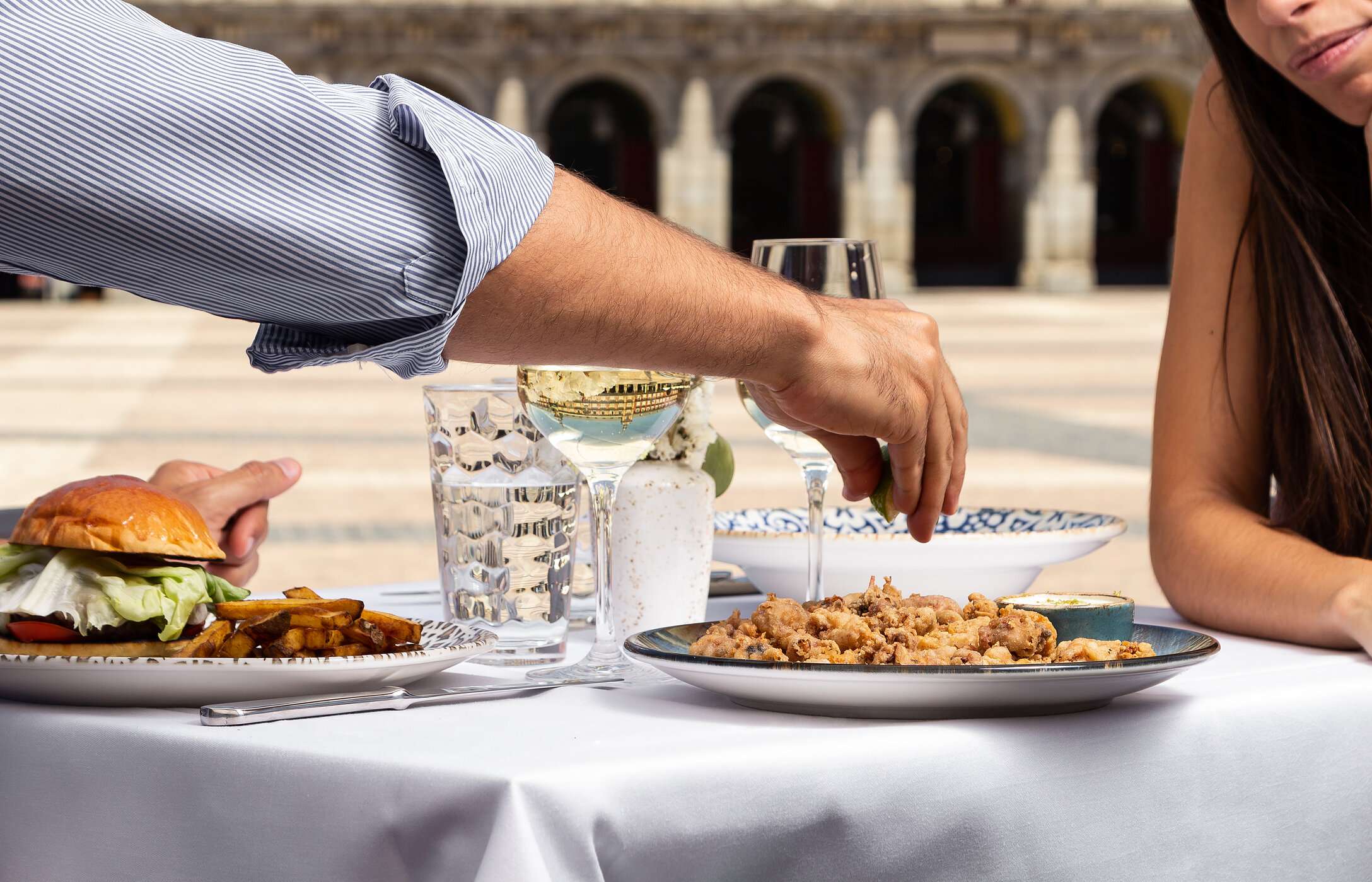 Mesa en un restaurante, en la terraza, en la Plaza Mayor en el centro de Madrid con dos platos servidos y dos copas de vino
