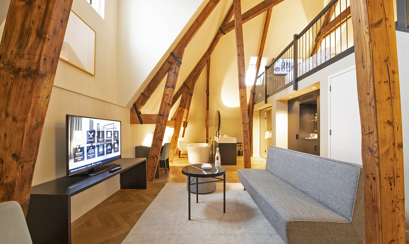 La Clock Tower Suite del Pestana Amsterdam Riverside tiene sala de estar con sofá, mesa de centro y televisión