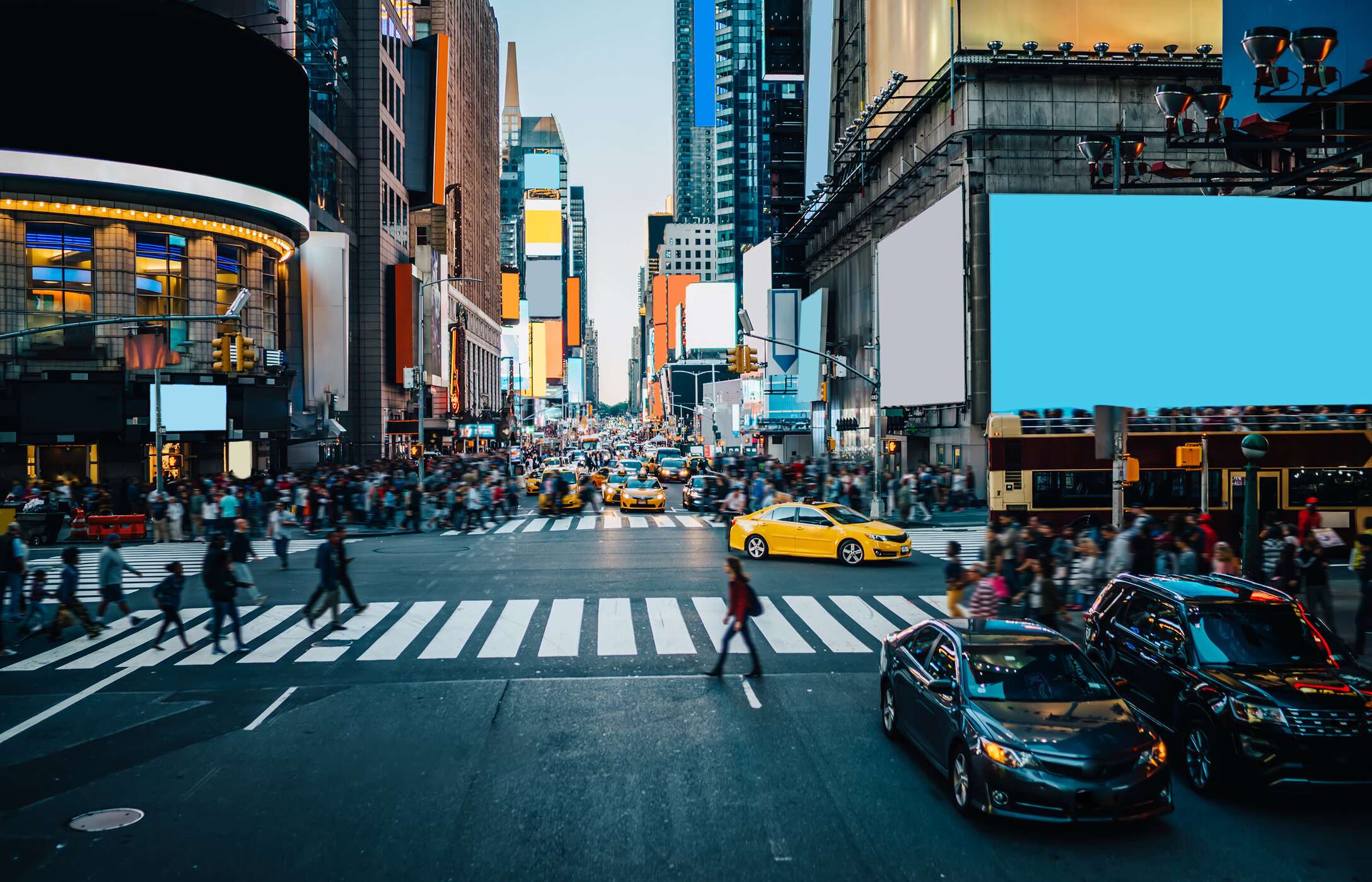  La famosa Times Square en Nueva York, bulliciosa con coches y gente, sus gigantes pantallas rodeadas de altos edificios.