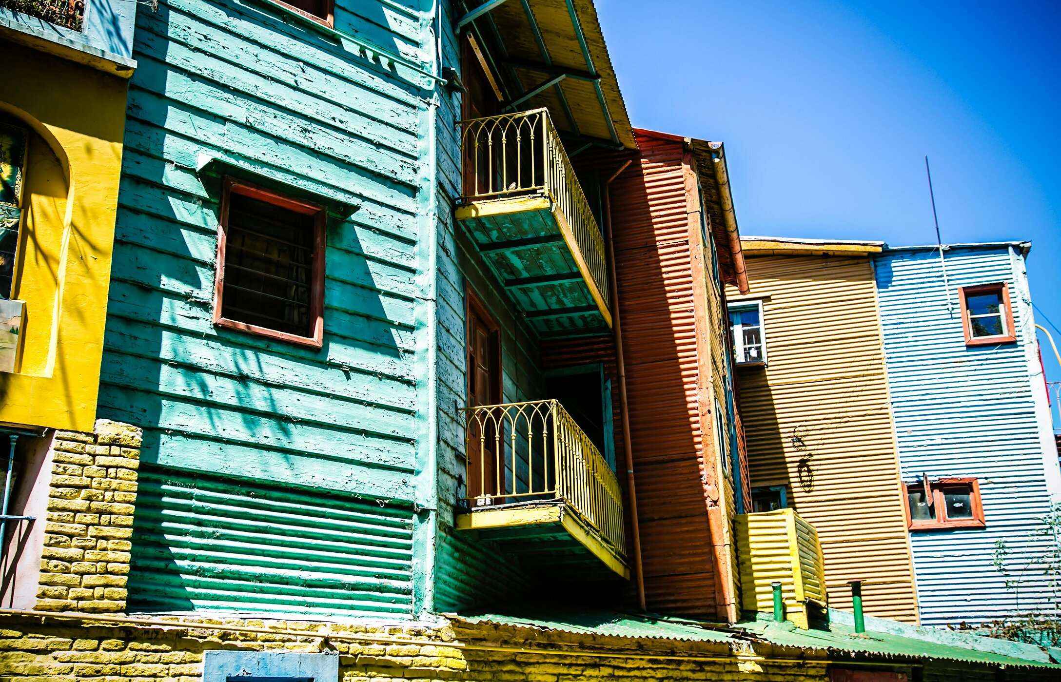 Façades de maisons en bois colorées avec balcons, typiques du quartier Caminito à Buenos Aires, Argentine