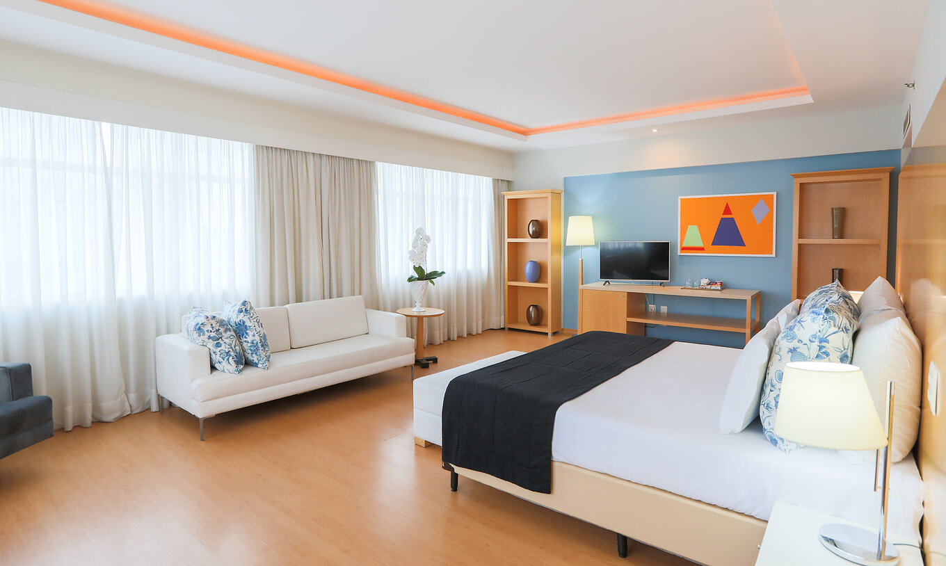 La Suite exécutive du Pestana Curitiba est spacieuse et lumineuse avec plusieurs fenêtres, un lit double et un canapé