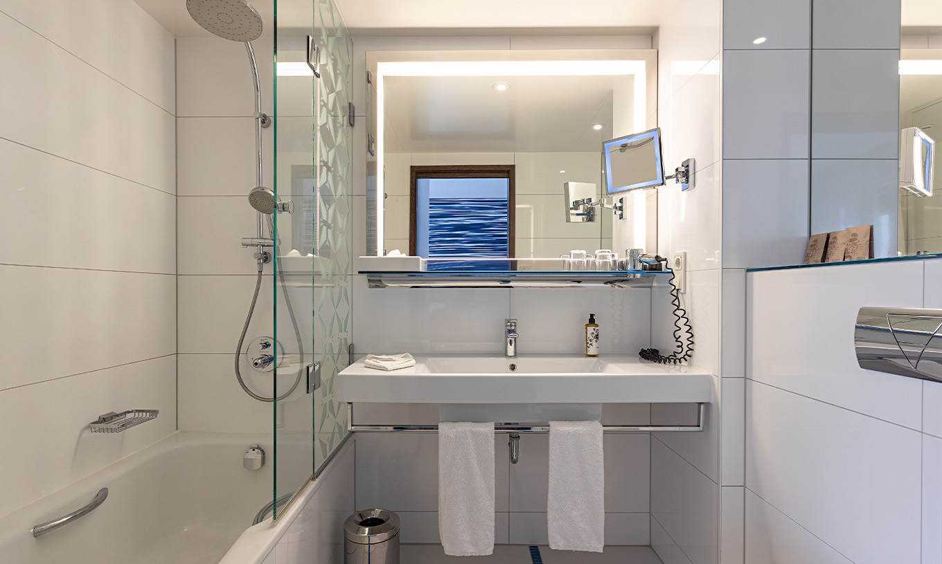 La Chambre Premium avec Balcon du Pestana Berlin Tiergarten a une Salle de Bain avec Douche, un Lavabo et un Miroir