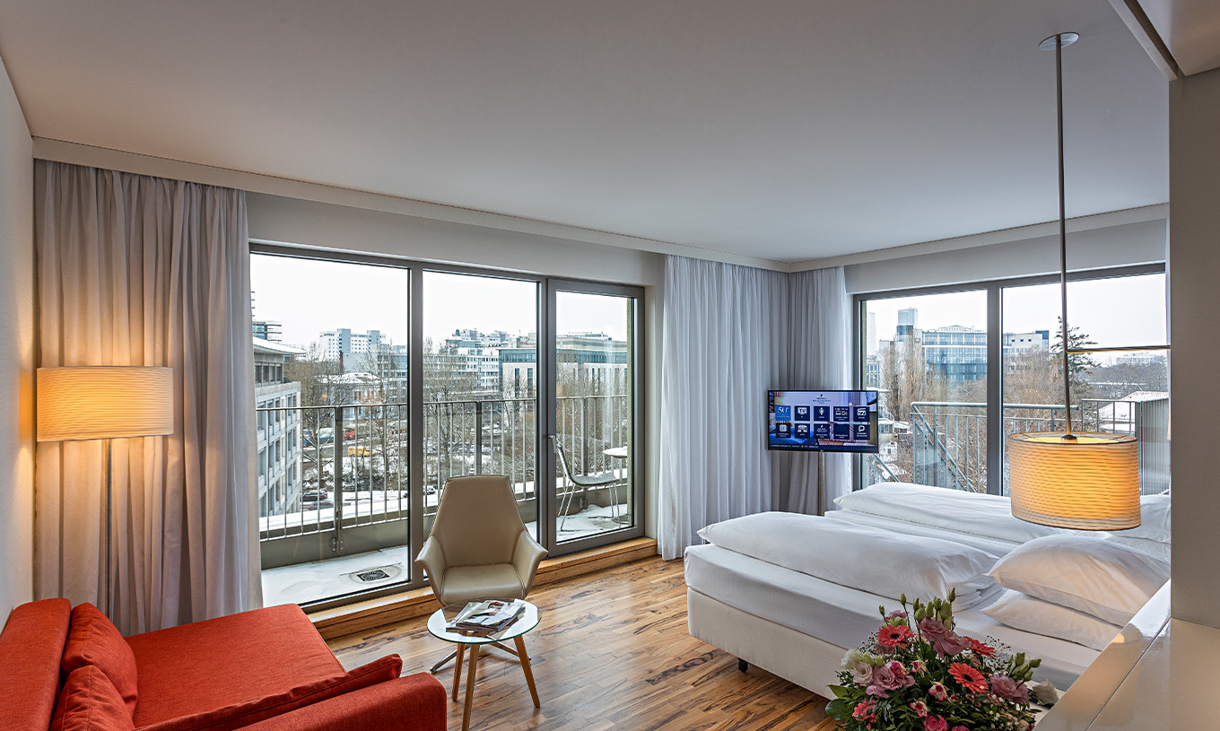 La Chambre Premium avec Balcon Panoramique du Pestana Berlin Tiergarten a un Canapé avec Lampe, Télévision et Lit