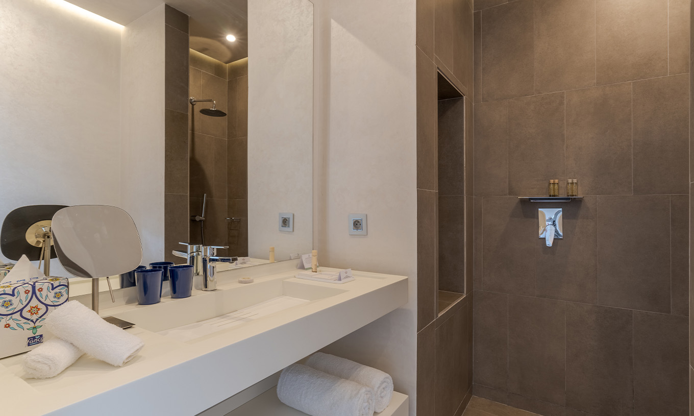 La suite Avenue du Pestana CR7 Marrakech a une salle de bain avec douche à l'italienne et lavabo avec miroir
