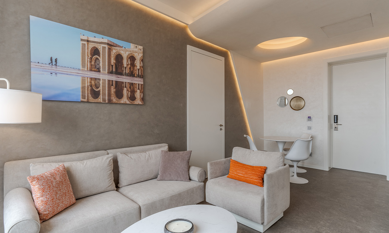 La suite du Pestana CR7 Marrakech a un salon avec deux canapés, un tableau et une table pour les repas